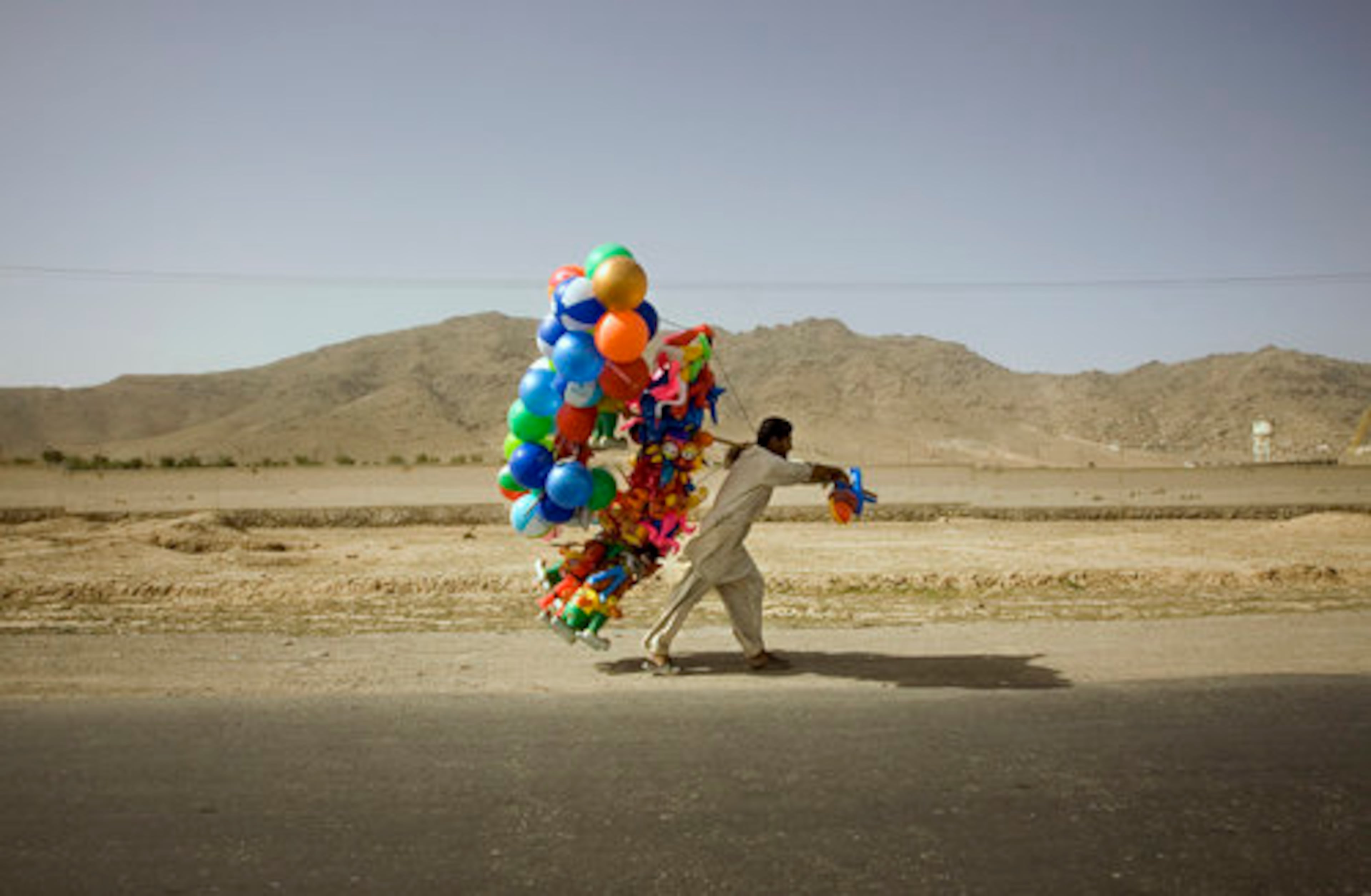 A man carries a bundle of balloons as he walks along a street on the outskirts of Kabul, Afghanistan, on Friday.