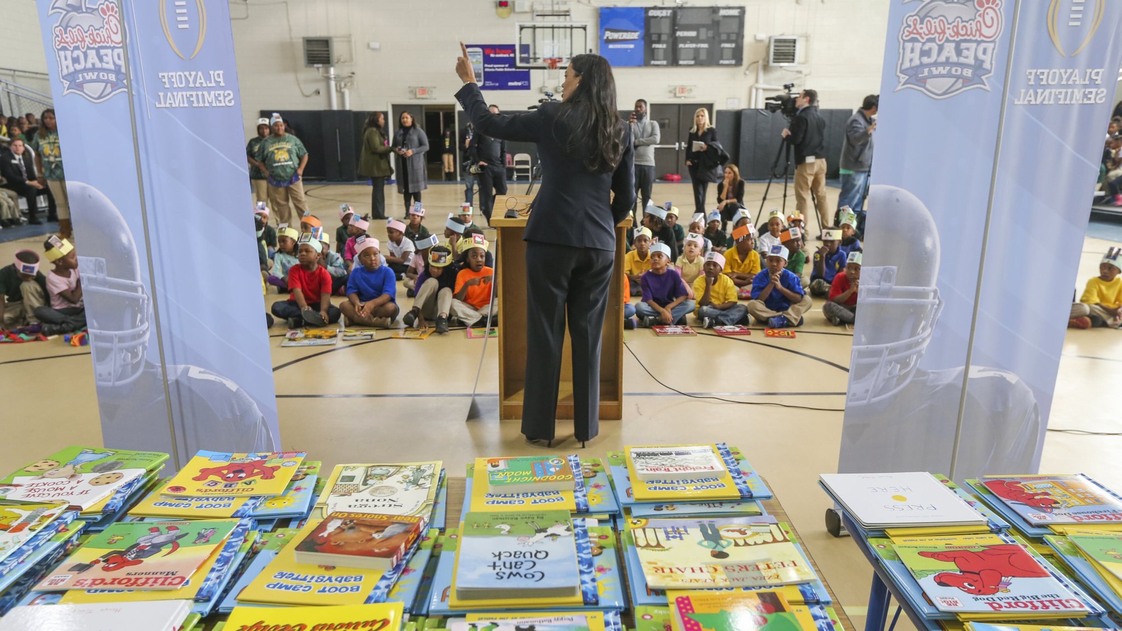 APS Superintendent Dr. Meria Carstarphen addresses students in front of a vast array of books that would be given to them at the end of the program. The Peach Bowl Inc. and the College Football Playoff Foundation teamed up to announce a $1-Million dollar initiative to improve early childhood literacy among kindergarten through 5th grade students at Boyd Elementary School at 2210 Perry Blvd NW in Atlanta on Thursday, Dec. 15, 2016. The grant will allow APS to train more than 1,000 educators in a specialized curriculum and to help them teach reading to students during their critical early years. JOHN SPINK /JSPINK@AJC.COM
