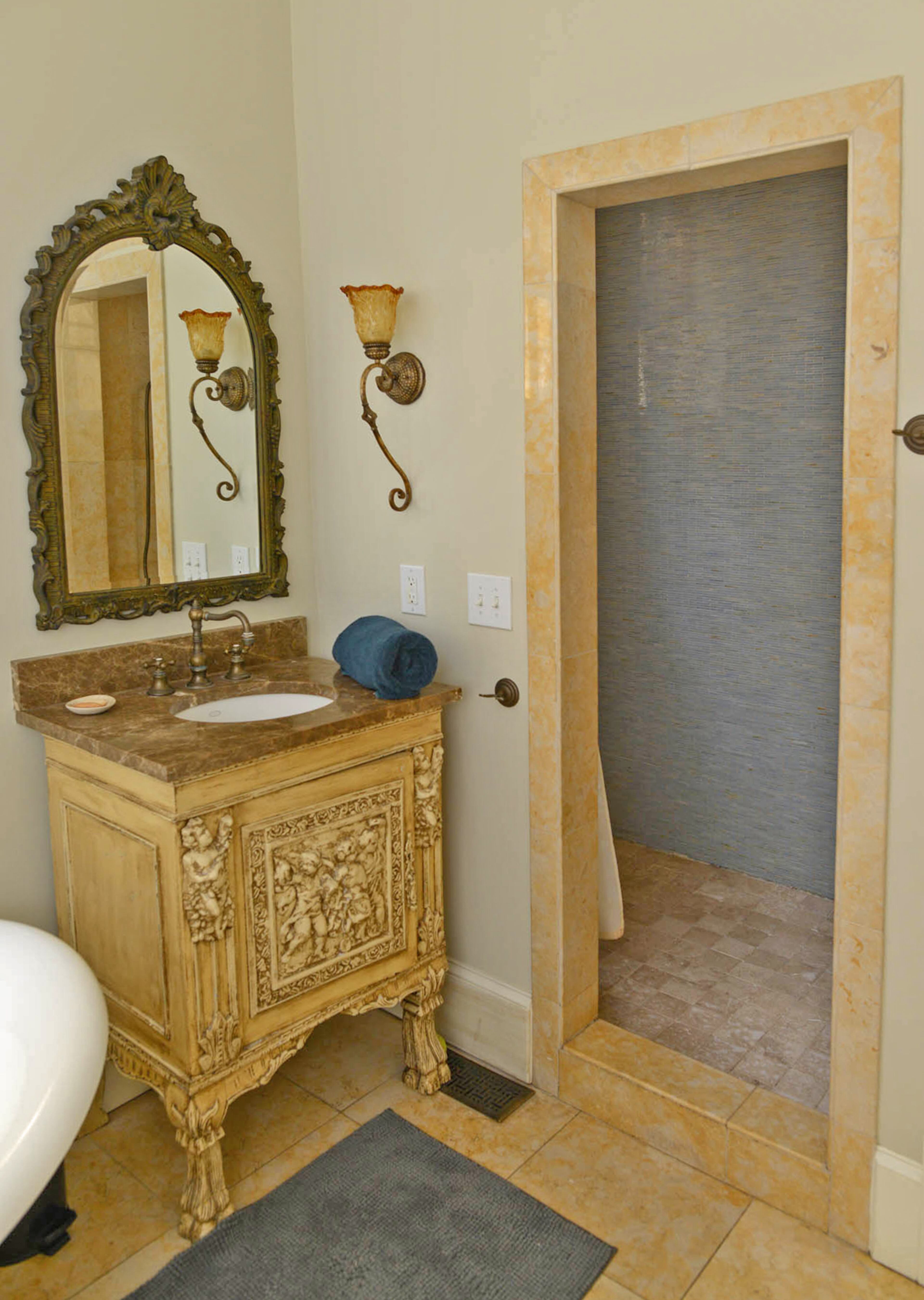 Walk-in showers immediately add a sense of luxe to any bathroom. The large master bathroom plays up the elegance factor by including both a walk-in shower, oversized tub and intricately carved cabinetry.