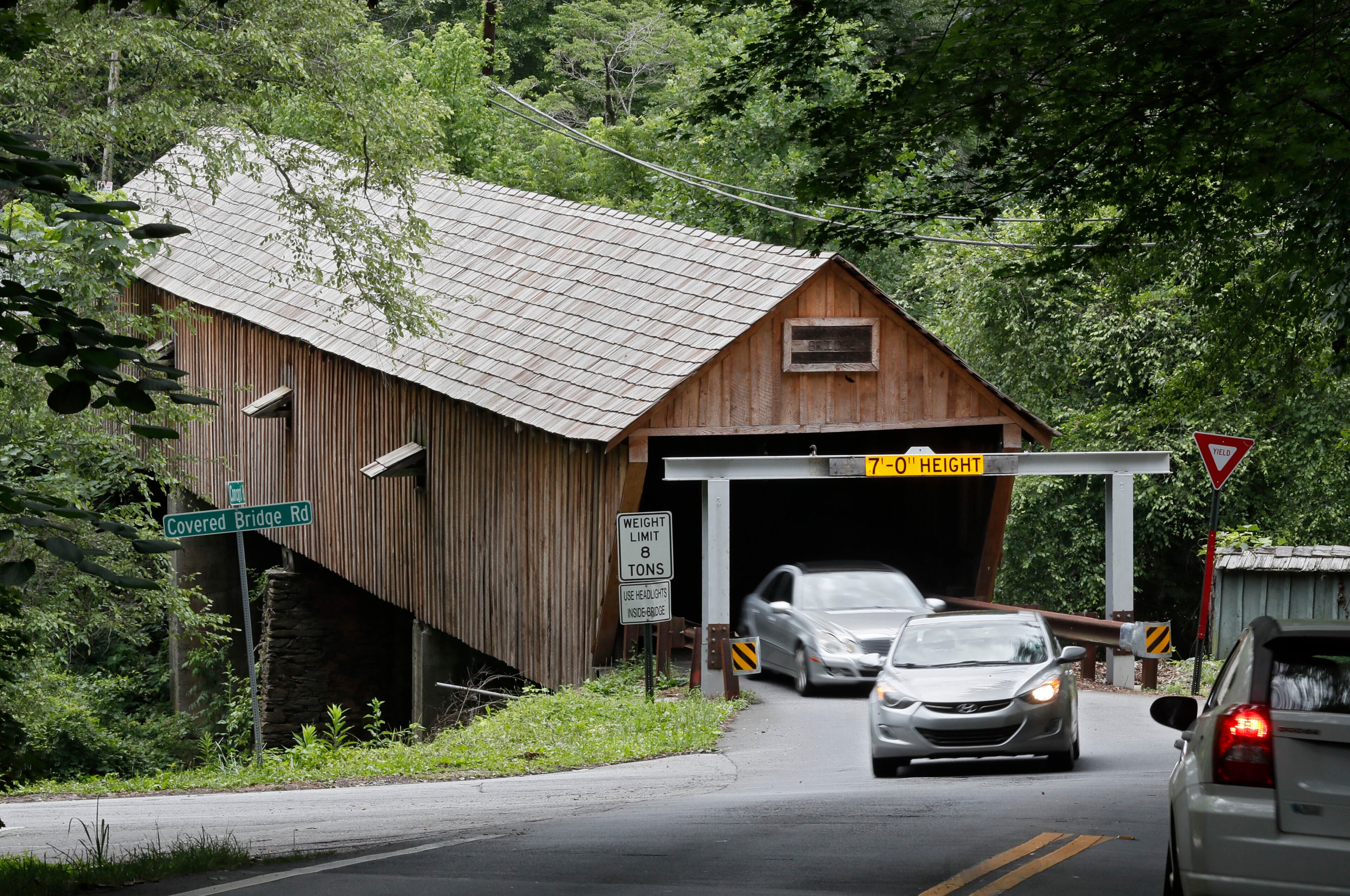 June 20, 2019 - Smyrna - Traffic moves through the Concord Road covered bridge. Cobb County is rolling out yet another tool designed to warn drivers of the seven-foot clearance of the Concord Road covered bridge. The county has installed mast arms along Concord Road that will have plastic-covered PVC pipes suspended at seven feet. If a too-tall vehicle hits these pipes, they should not try to pass through the covered bridge. Bob Andres / bandres@ajc.com
