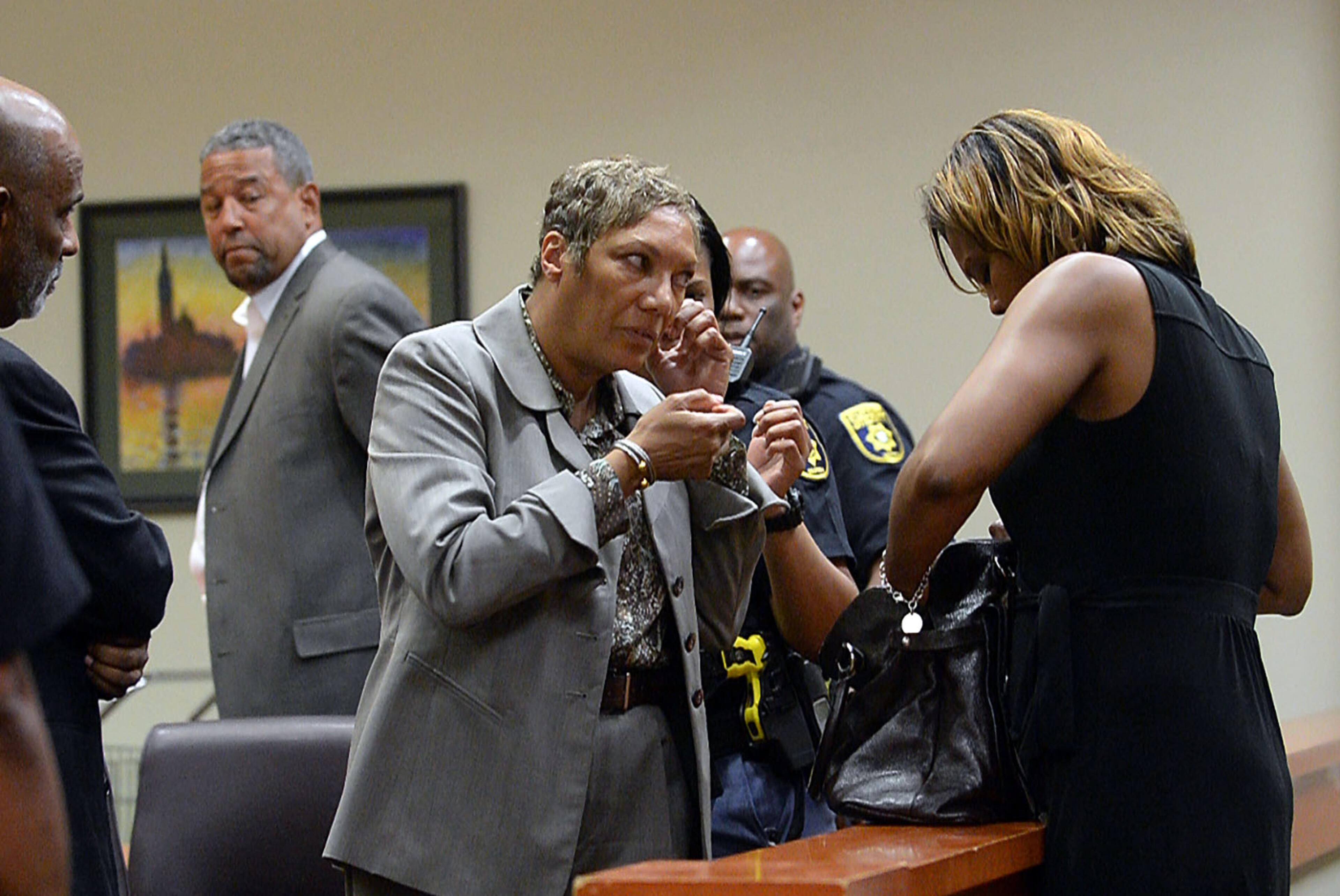 .Pat Reid takes off jewelry as she and Tony Pope are returned to custody after DeKalb Superior Court Judge Gregory A. Adams signed an arrest warrant following a motions hearing, Tuesday, May 12, 2015. They're asking for a new trial and petitioning to be released from prison awaiting the trial. KENT D. JOHNSON /KDJOHNSON@AJC.COM