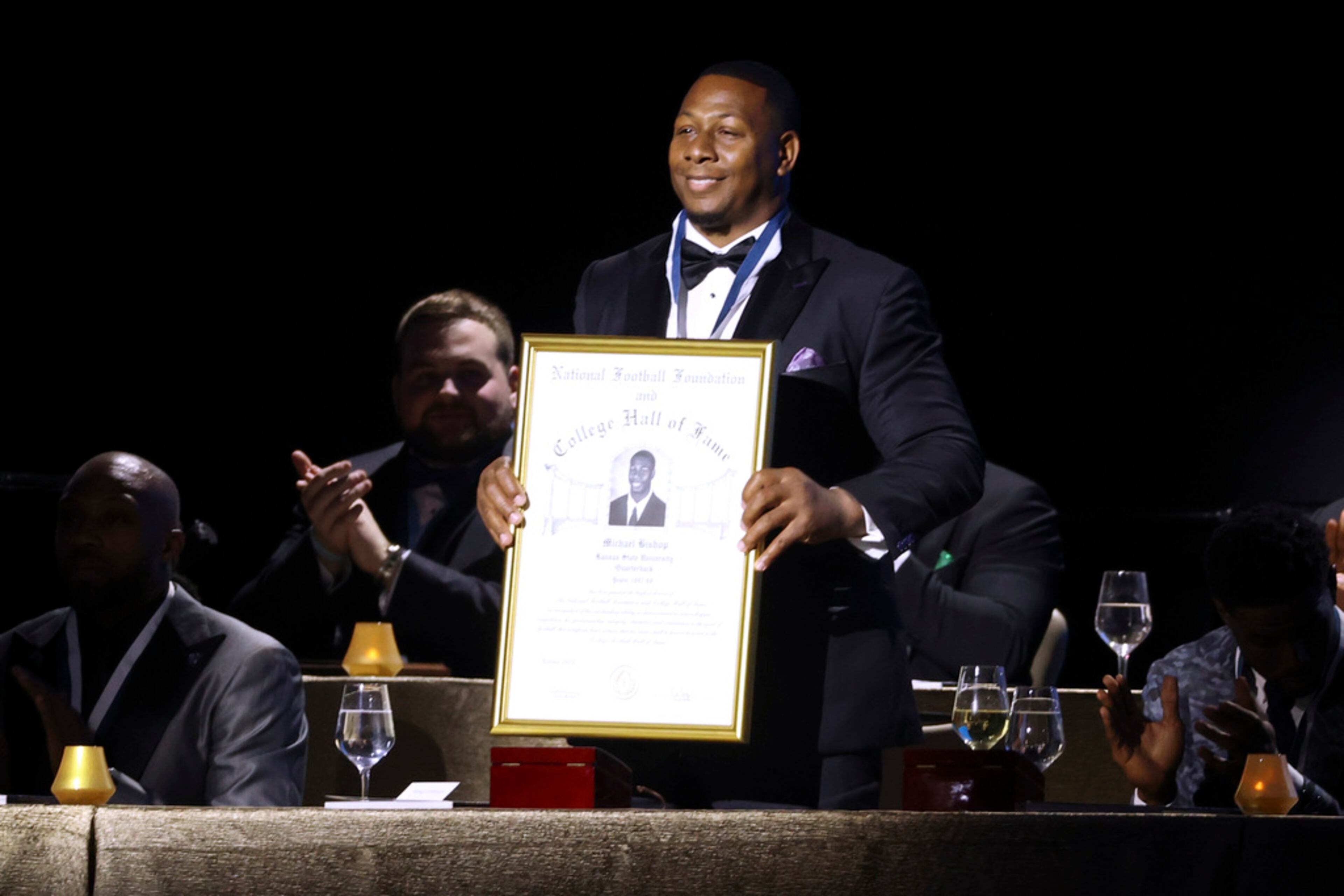 Former Kansas State quarterback Michael Bishop holds up his College Football Hall of Fame Award during the National Football Foundation Awards Dinner, Tuesday, Dec. 5, 2023, in Las Vegas. (AP Photo/Ian Maule)