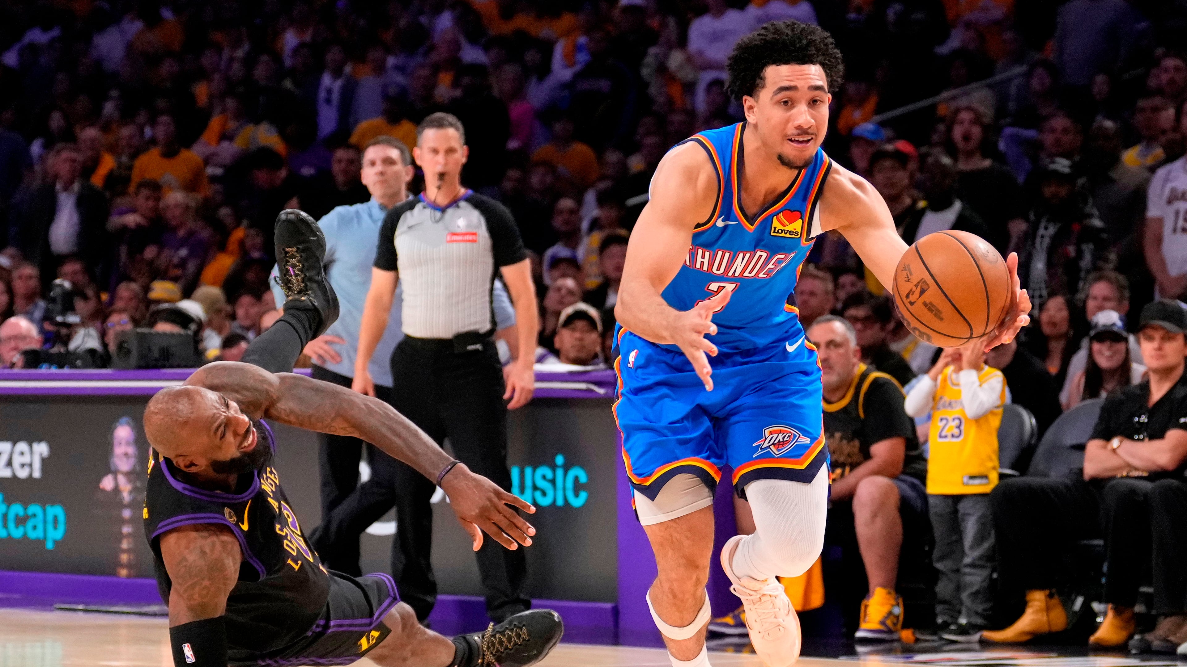Oklahoma City Thunder guard Jared McCain, right, drives toward the basket as Los Angeles Lakers forward LeBron James falls during the second half of Game 4 in a second-round NBA basketball playoffs series Monday, May 11, 2026, in Los Angeles. (AP Photo/Mark J. Terrill)