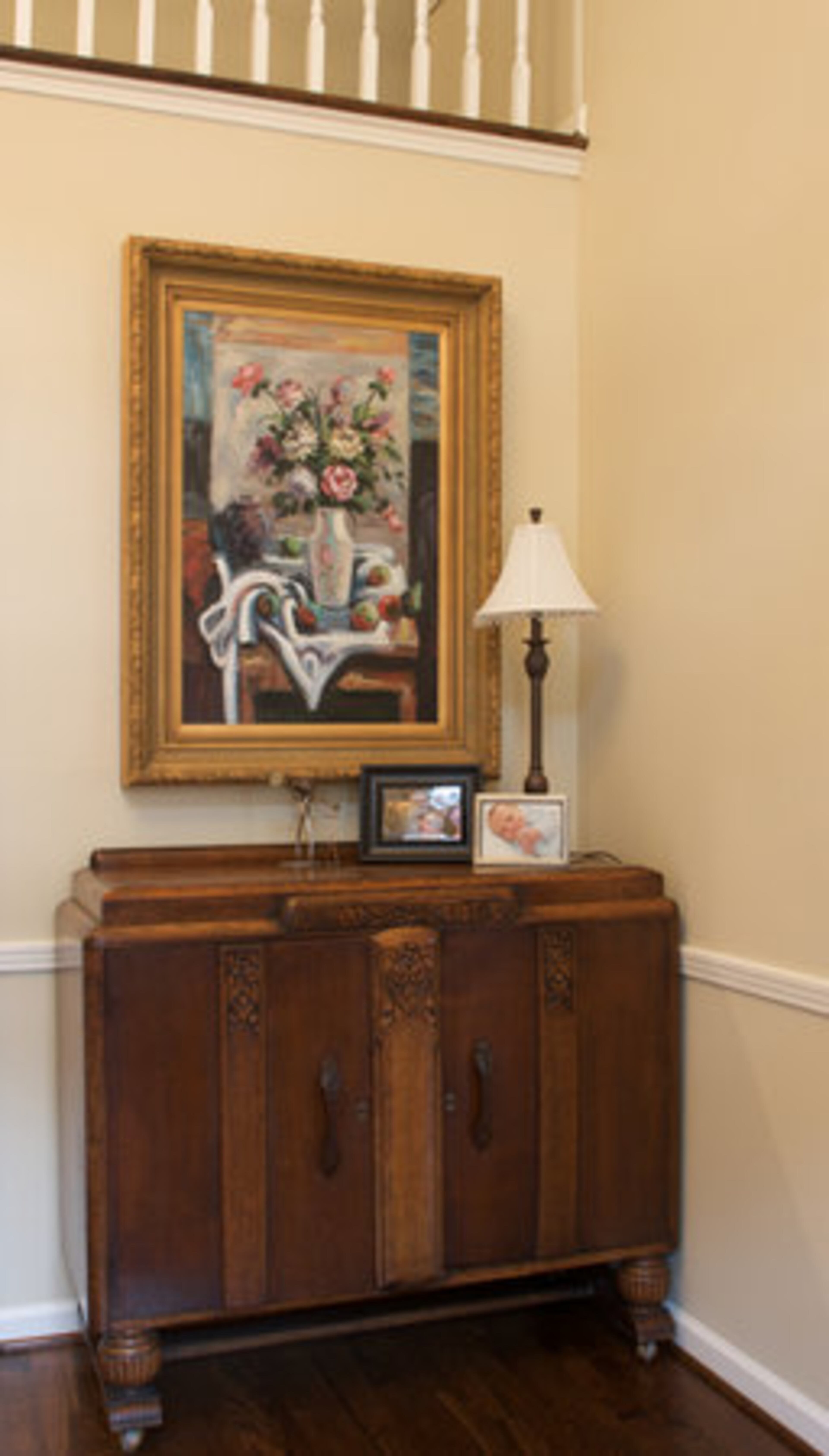 An antique Empire cabinet decorates the foyer. The foyer allows traffic to flow into the living room, family room and kitchen area or upstairs to the family bedrooms.