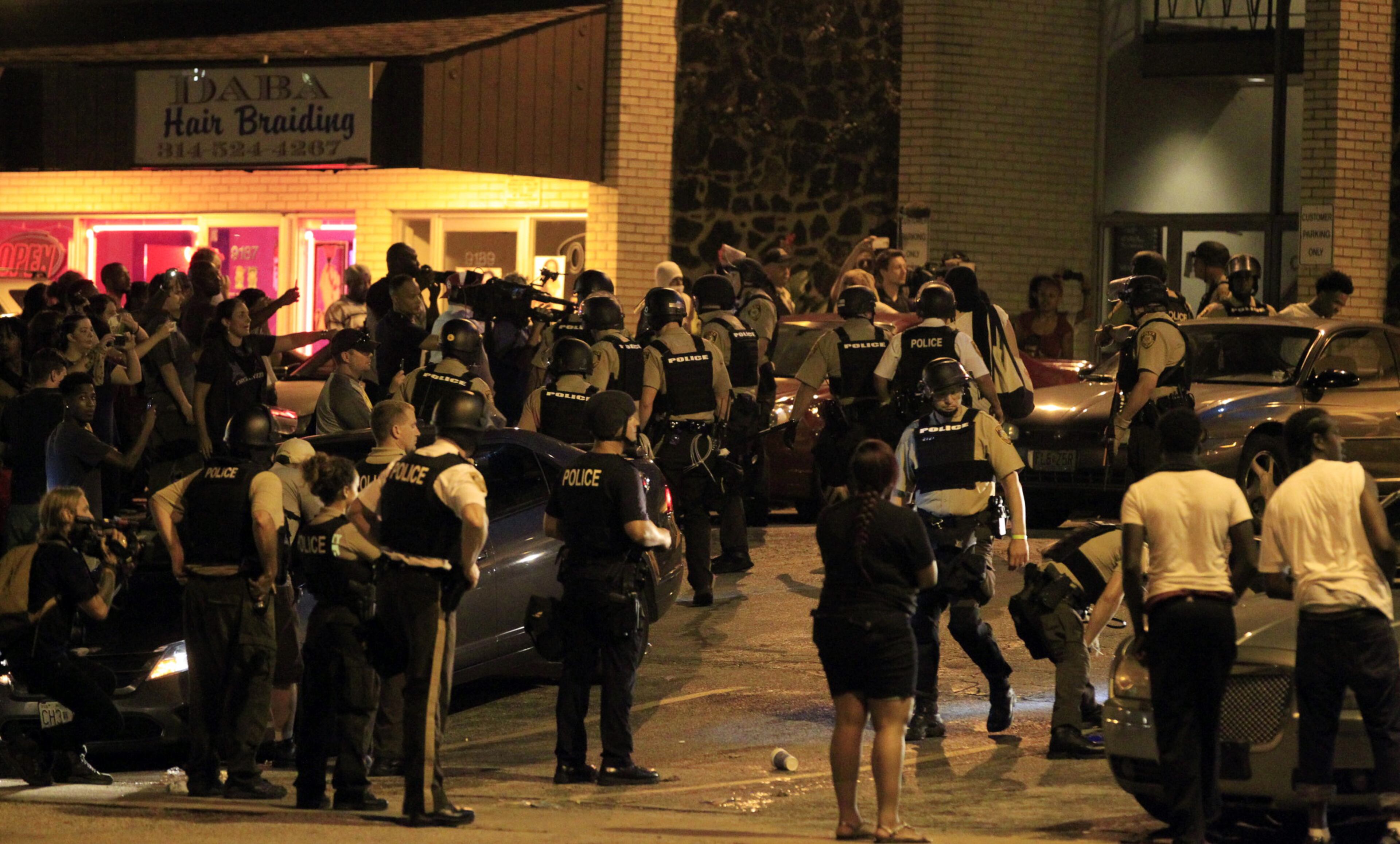 Officers move in to break up a crowd Aug. 10, 2015, in Ferguson, Mo. Ferguson was a community on edge again Monday, a day after a protest marking the anniversary of Michael Brown's death was punctuated with gunshots.