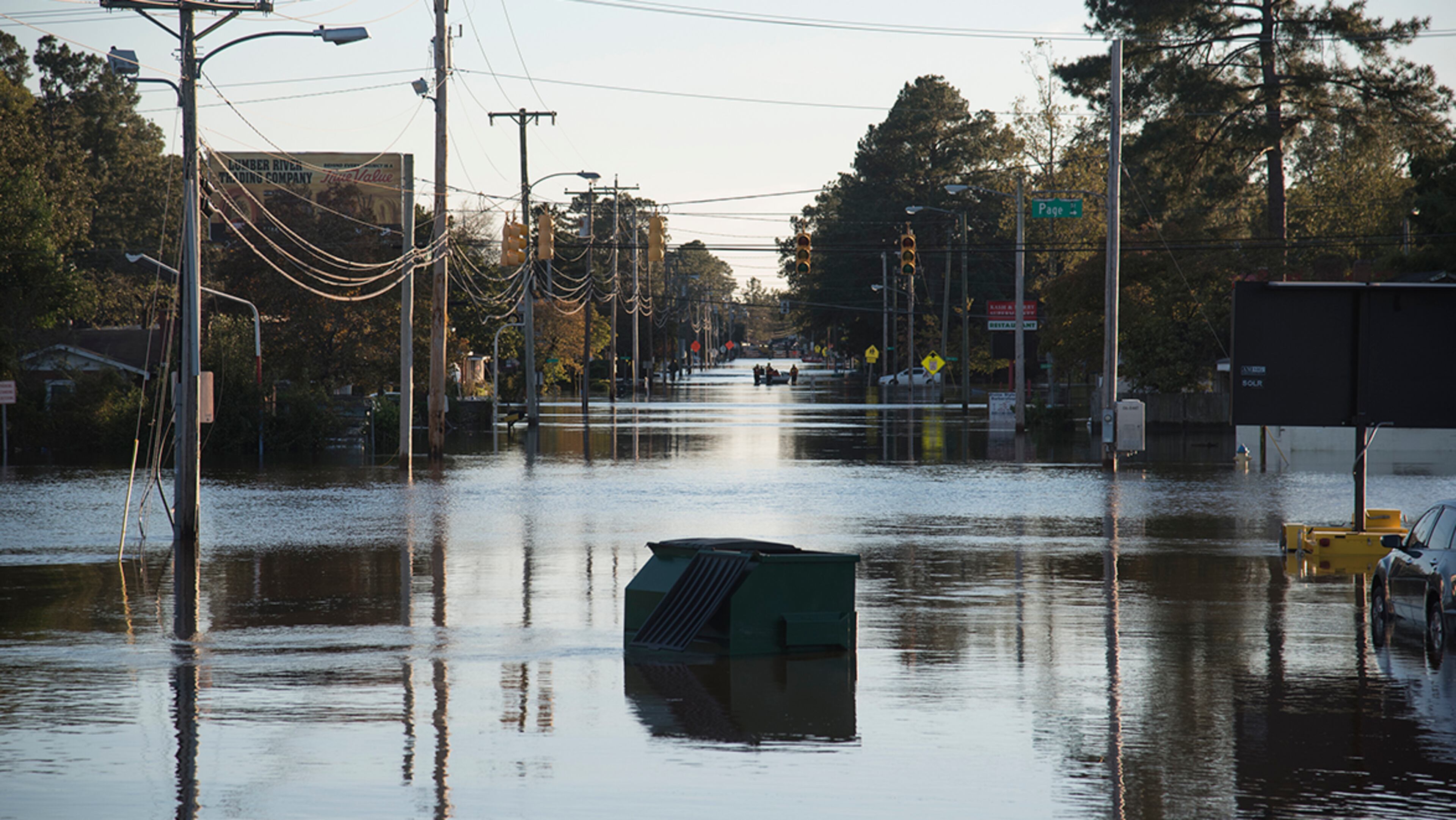A garbage dumpster came to rest in the middle of Martin Luther King Jr. Drive in floodwaters caused by rain from Hurricane Matthew in Lumberton, N.C., Monday, Oct. 10, 2016. (AP Photo/Mike Spencer)