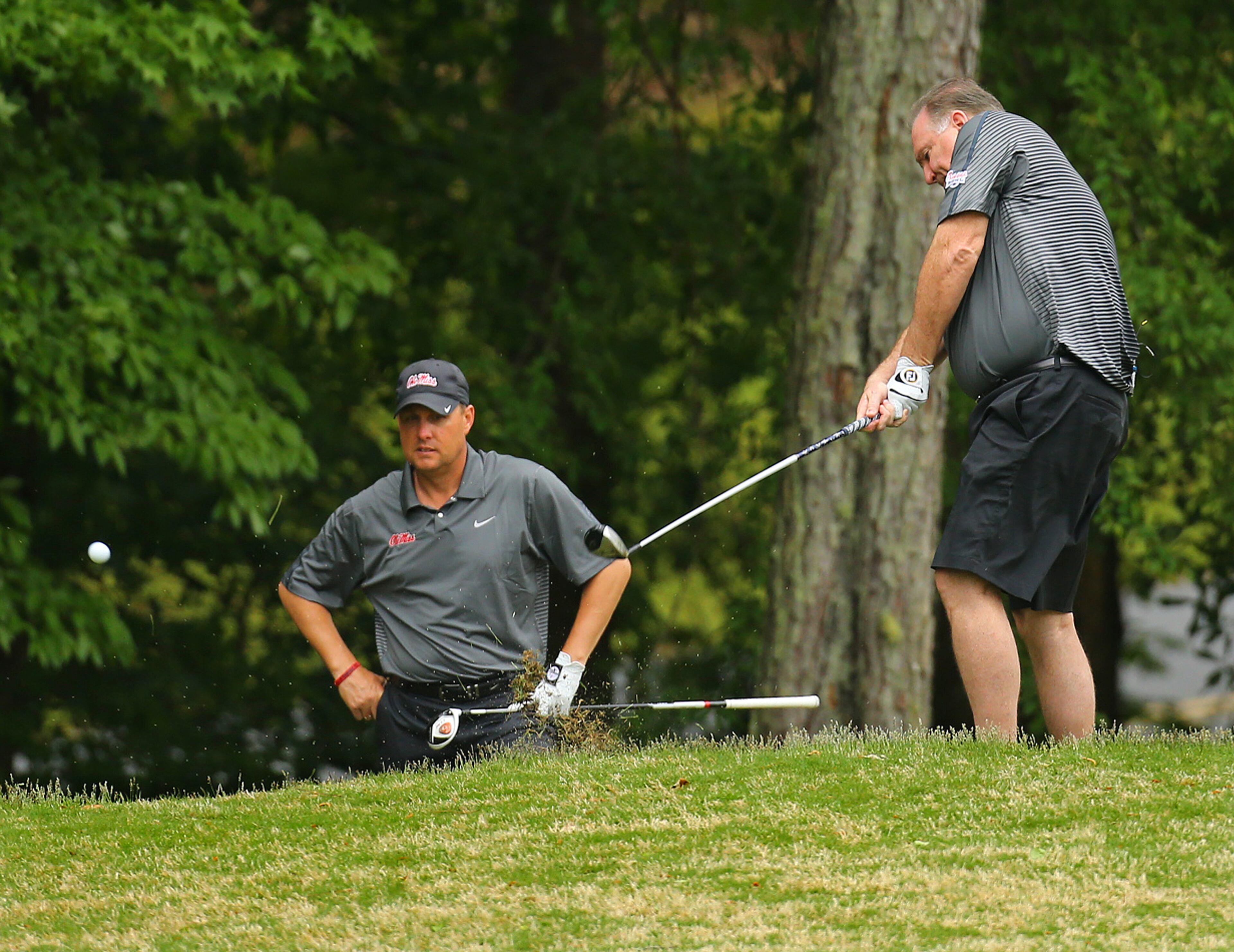Ole Miss head coach Hugh Freeze hits his second shot toward the No. 7 green with celebrity alumni Sean Tuohy looking on during the Chick-fil-A Bowl Challenge featuring an 11 team field of NCAA head coaches and celebrity alumni at Reynolds Plantation on Tuesday, April 29, 2014, in Greensboro. Teams compete for a share of the $520,000 scholarship purse for their universities. CURTIS COMPTON / CCOMPTON@AJC.COM