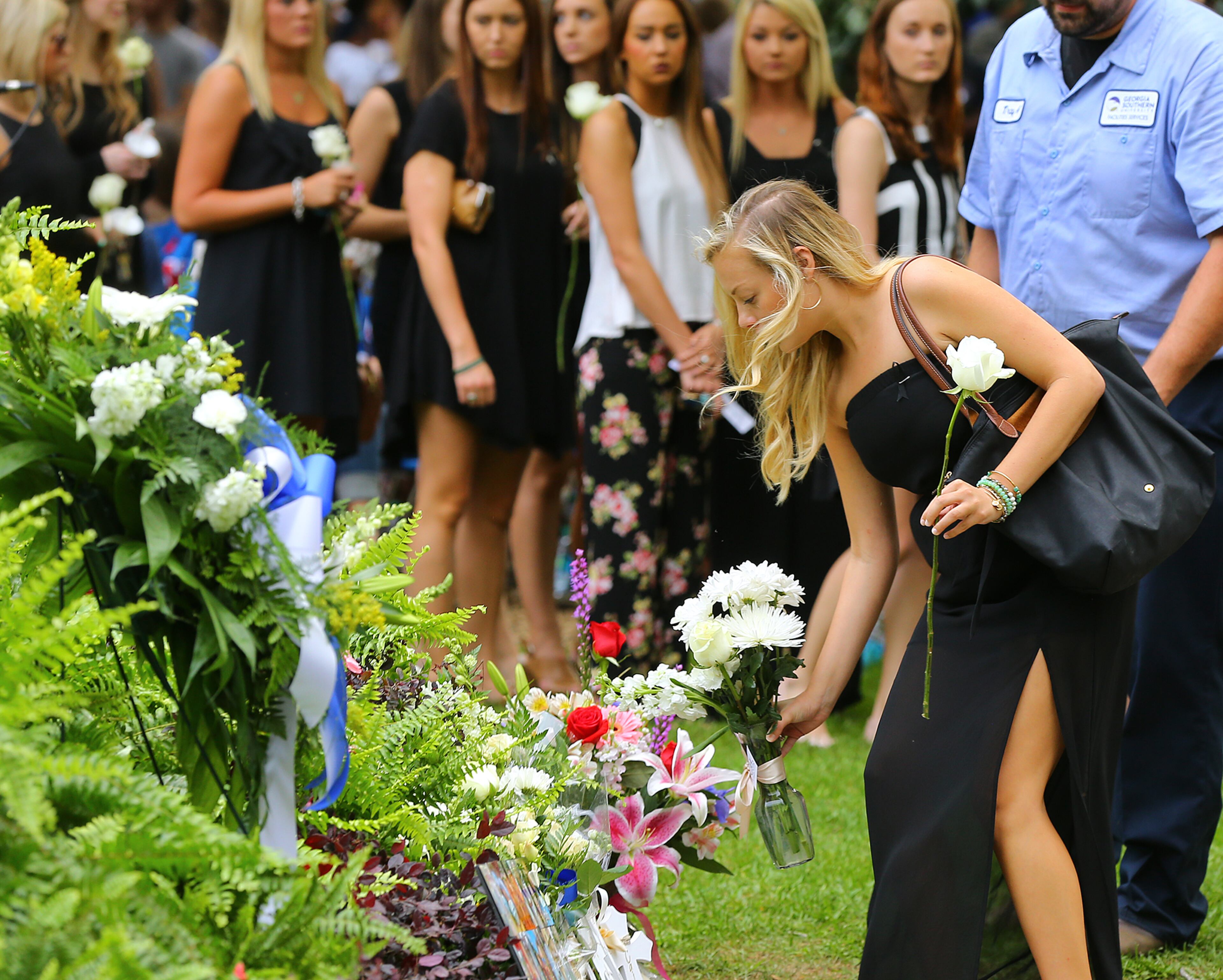 A student adds her flowers to the display as thousands gather for the Memorial Service at Georgia Southern University for five nursing students on Thursday, April 23, 2015, in Statesboro. Curtis Compton / ccompton@ajc.com