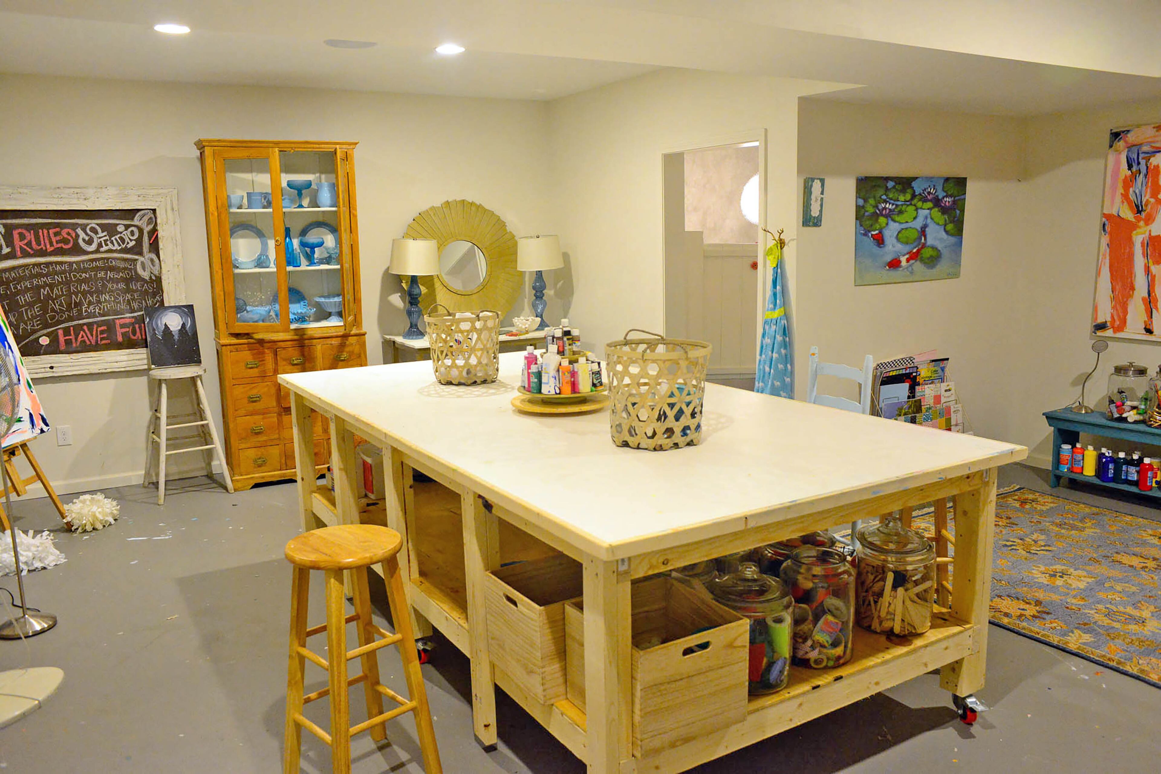A custom work island by Carey Durbin of CD Natural Creations is set on casters so it's easy to move around Charyl and Anthony Ware's basement art studio. The laminate top and concrete floors makes it easy to clean up spills and messes. The studio, which was finished by Modify Atlanta, is often filled with kids and pets. Christopher Oquendo/AJC FILE