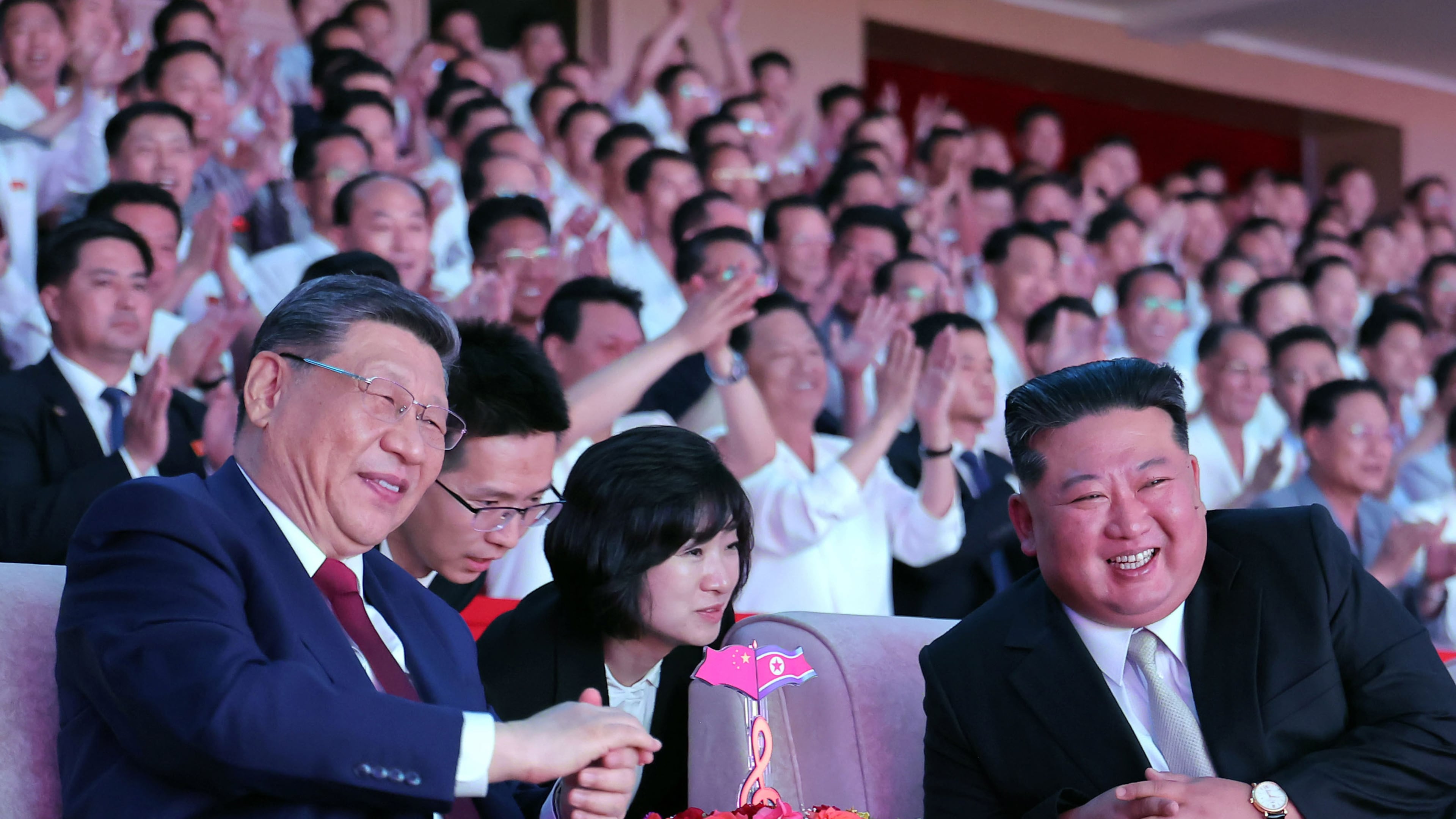 In this photo provided by the North Korean government, North Korean leader Kim Jong Un, right, and Chinese President Xi Jinping, left, smile as they watch welcome performance at Pyongyang Gymnasium in Pyongyang, Monday, June 8, 2026. Independent journalists were not given access to cover the event depicted in this image distributed by the North Korean government. The content of this image is as provided and cannot be independently verified. Korean language watermark on image as provided by source reads: "KCNA" which is the abbreviation for Korean Central News Agency. (Korean Central News Agency/Korea News Service via AP)