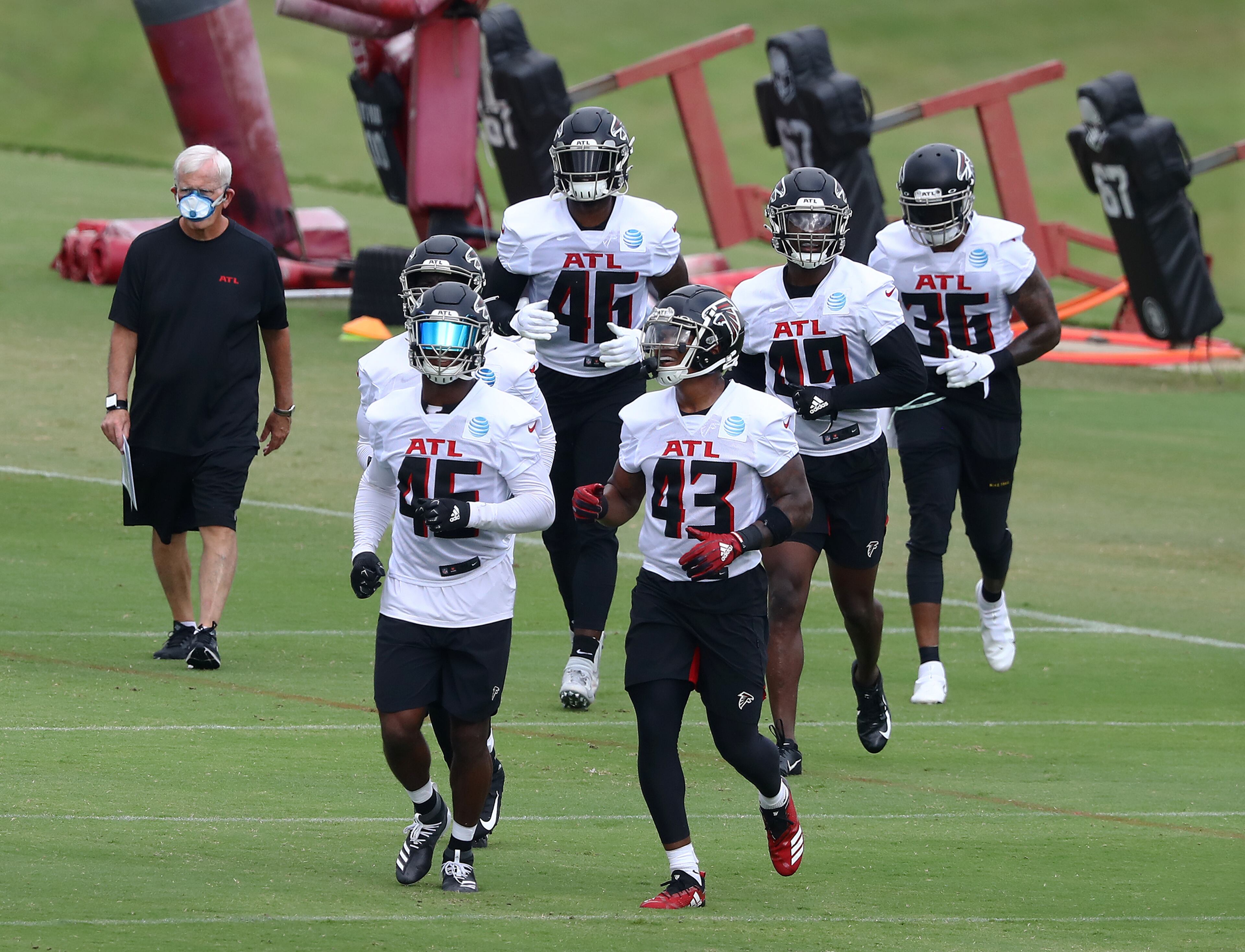 Falcons veteran Deion Jones (left) and rookie Mykal Walker (right) lead the linebackers to the next set of drills. Curtis Compton ccompton@ajc.com