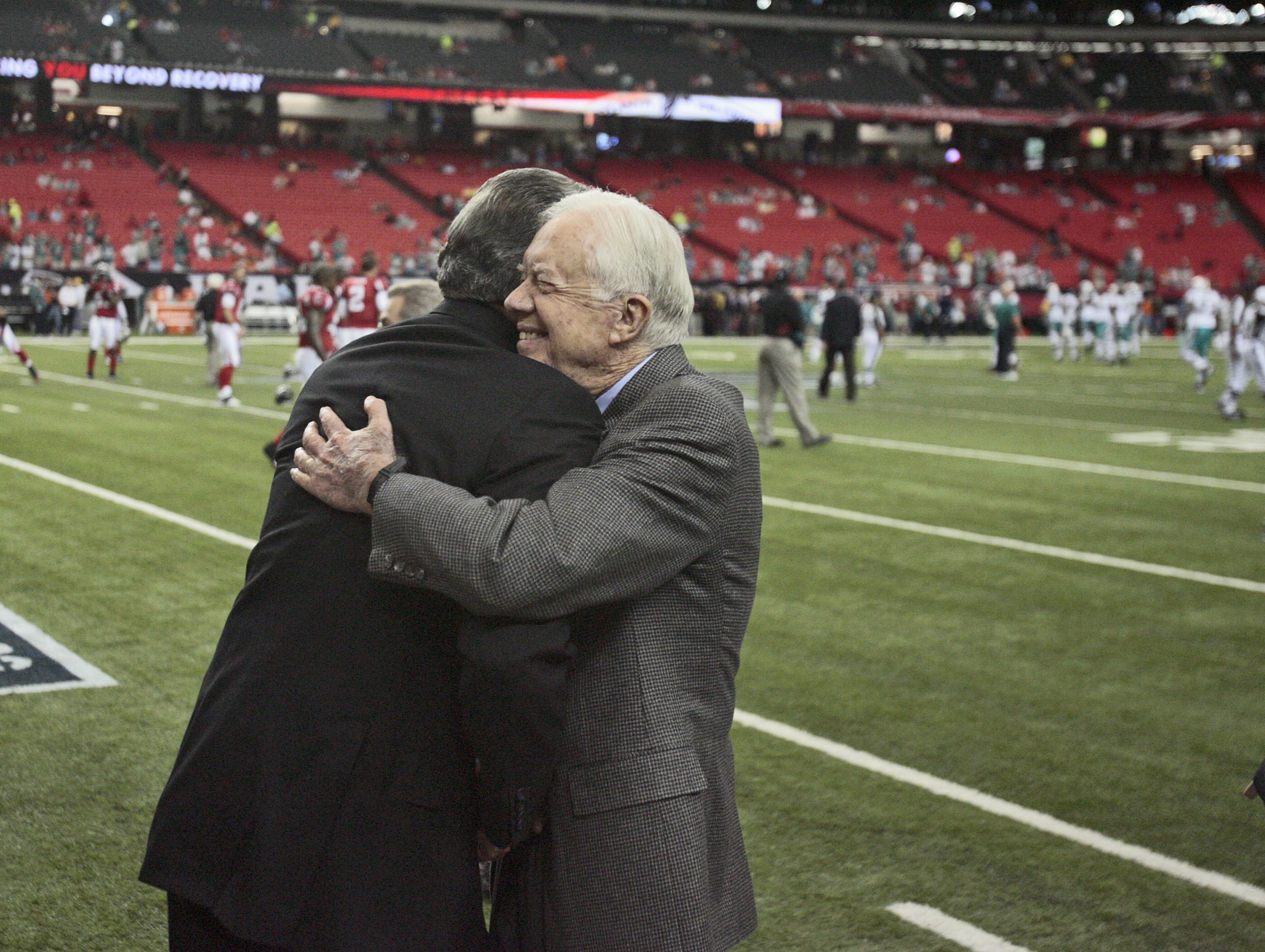 Former president Jimmy Carter gives Falcons owner Arthur Blank a hug during the teams pre-game warm ups. NFL season opener between the Atlanta Falcons and the Miami Dolphns at the Georgia Dome in Atlanta. Sun, Sep. 13, 2009. Bob Andres, bandres@ajc.com