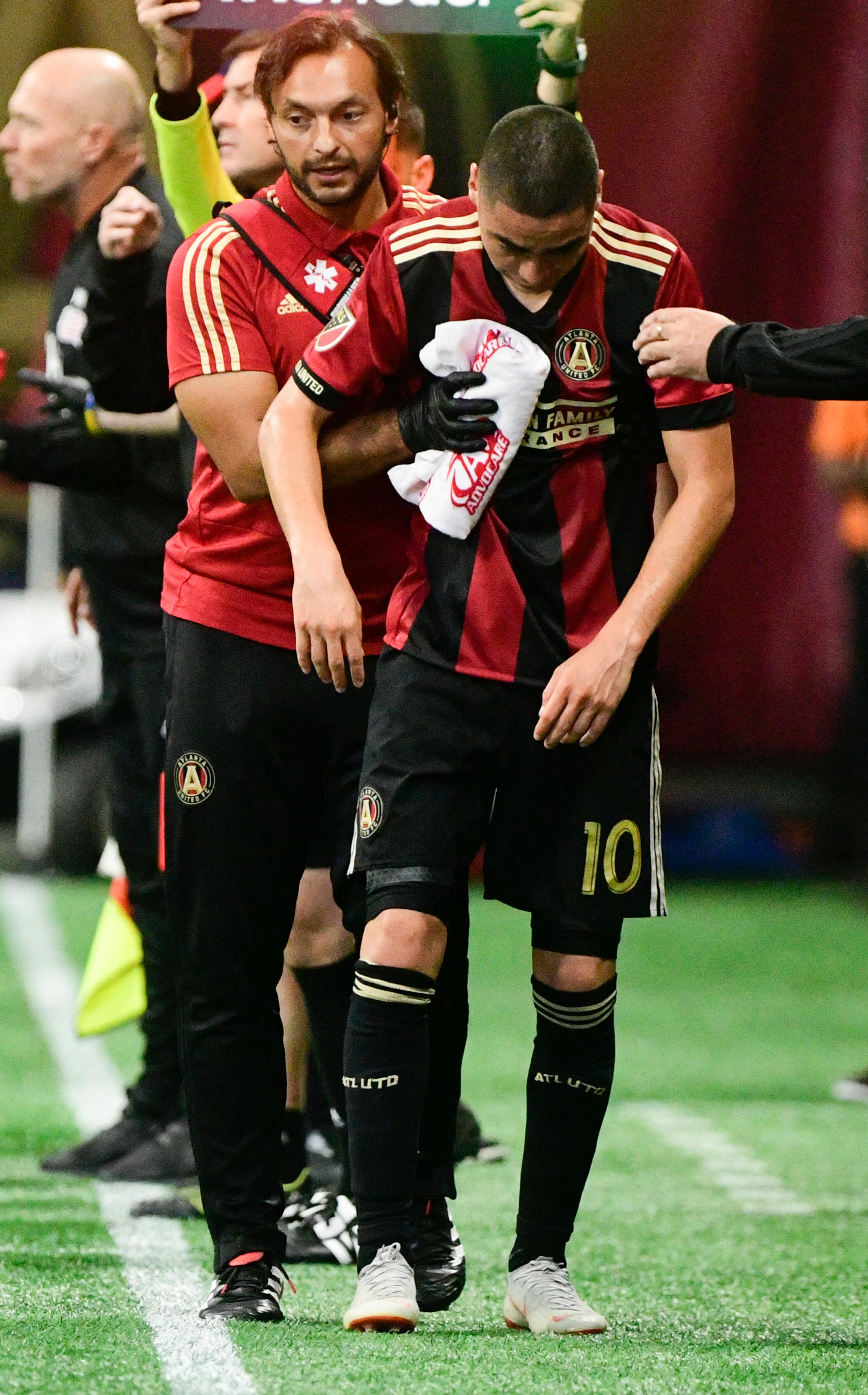 Atlanta United midfielder Miguel Almiron (10) is helped off the field injured during the first half of an MLS soccer game against the New England Revolution, Saturday, Oct. 6, 2018. (John Amis)