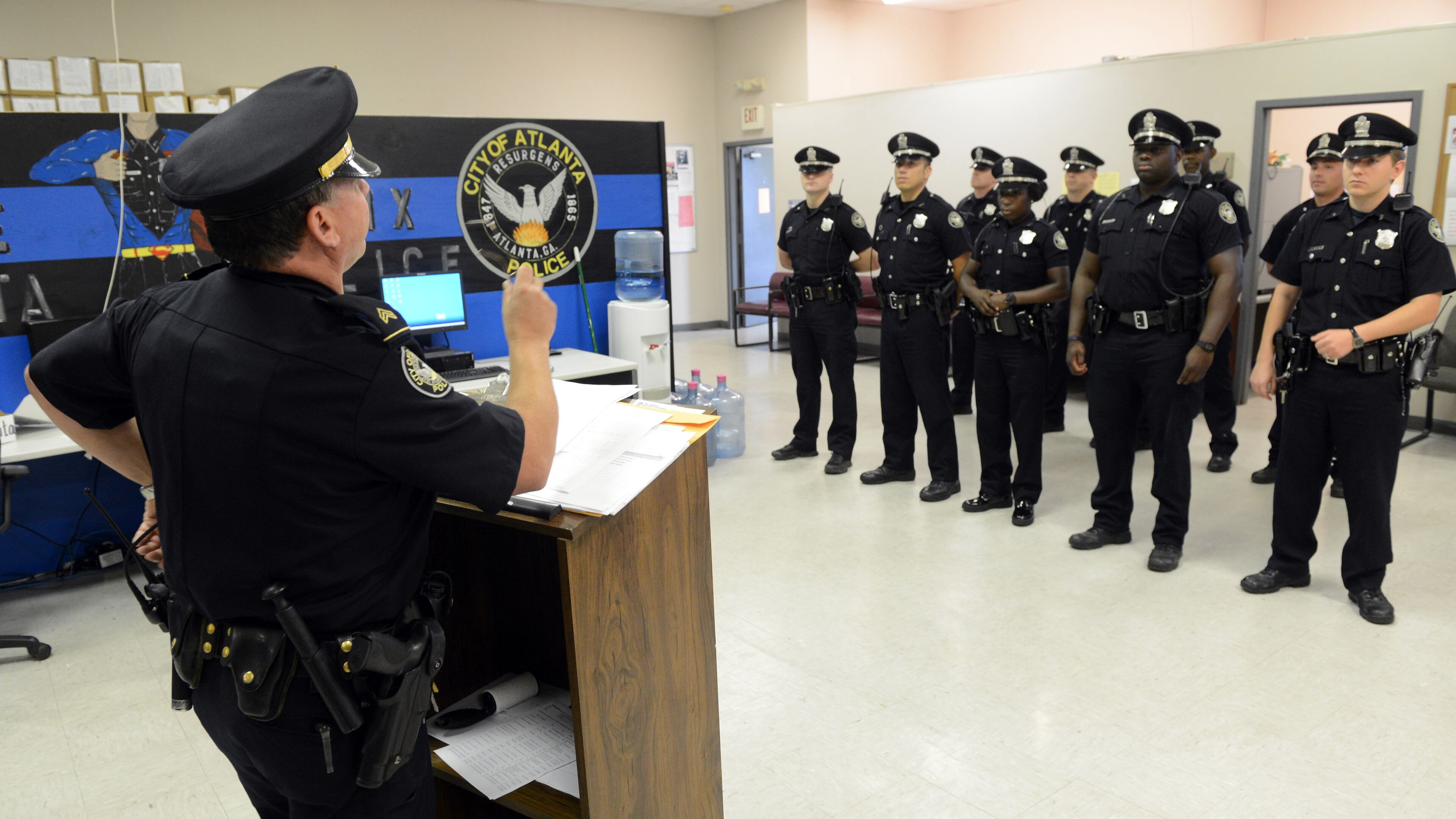 Atlanta Police Sgt A. Gruen conducts roll call briefing for APDofficers in the Zone 6, East Precinct, before they deploy in the area Tuesday, June 4, 2013. Crime is down statistically and there are more police officers on the street at anytime over the past two decades. Yet, many city residents still feel unsafe. And when crime visits, as it did in East Atlanta during a string of violent armed robberies -- one that ended in a murder -- citizens react by calling for more patrols, or even paying for their own.