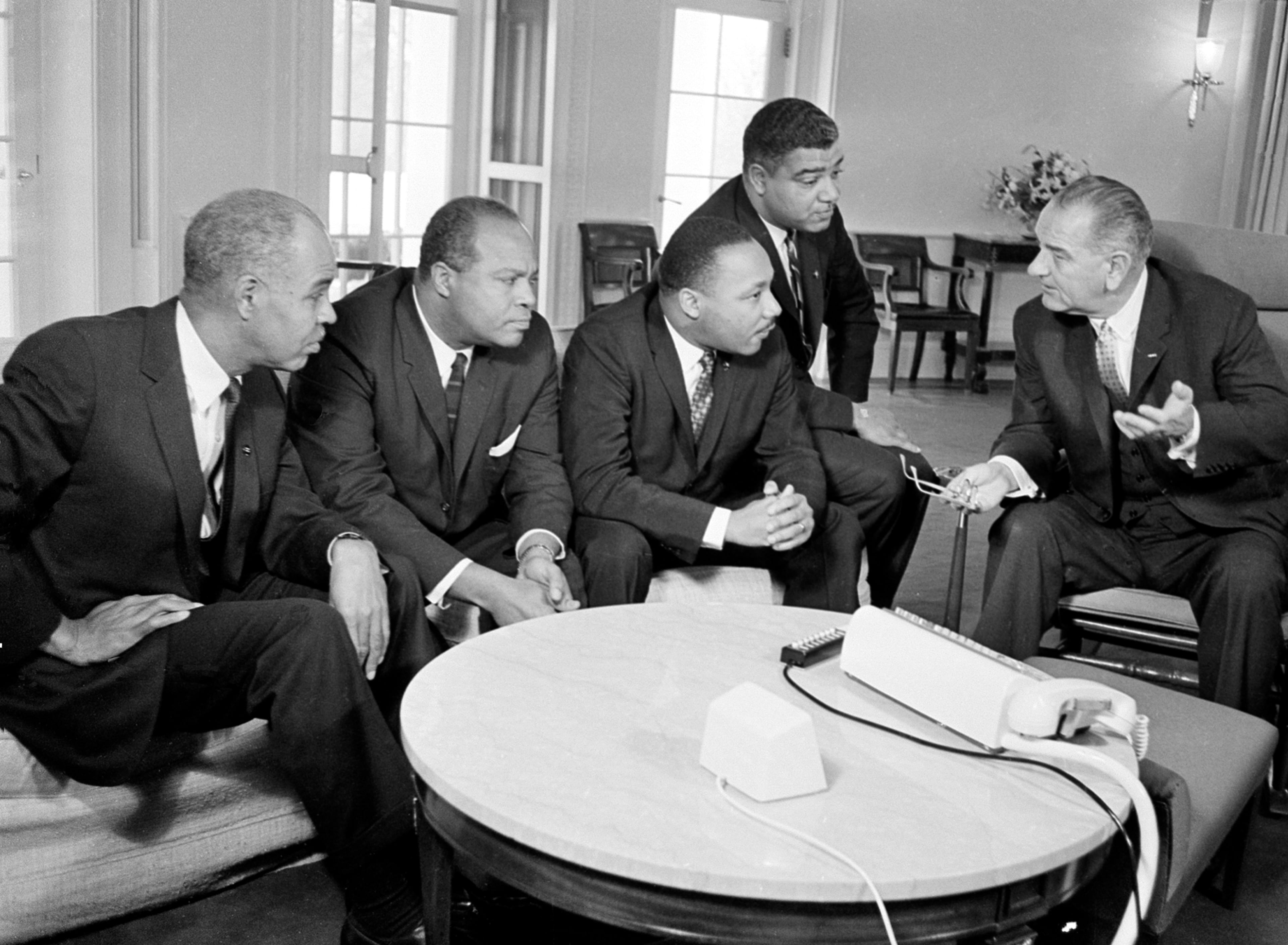 U.S. President Lyndon B. Johnson (right) talks in his White House office in 1964 with civil rights leaders (from left) Roy Wilkins, James Farmer, the Rev. Martin Luther King Jr. and Whitney Young. (Associated Press)