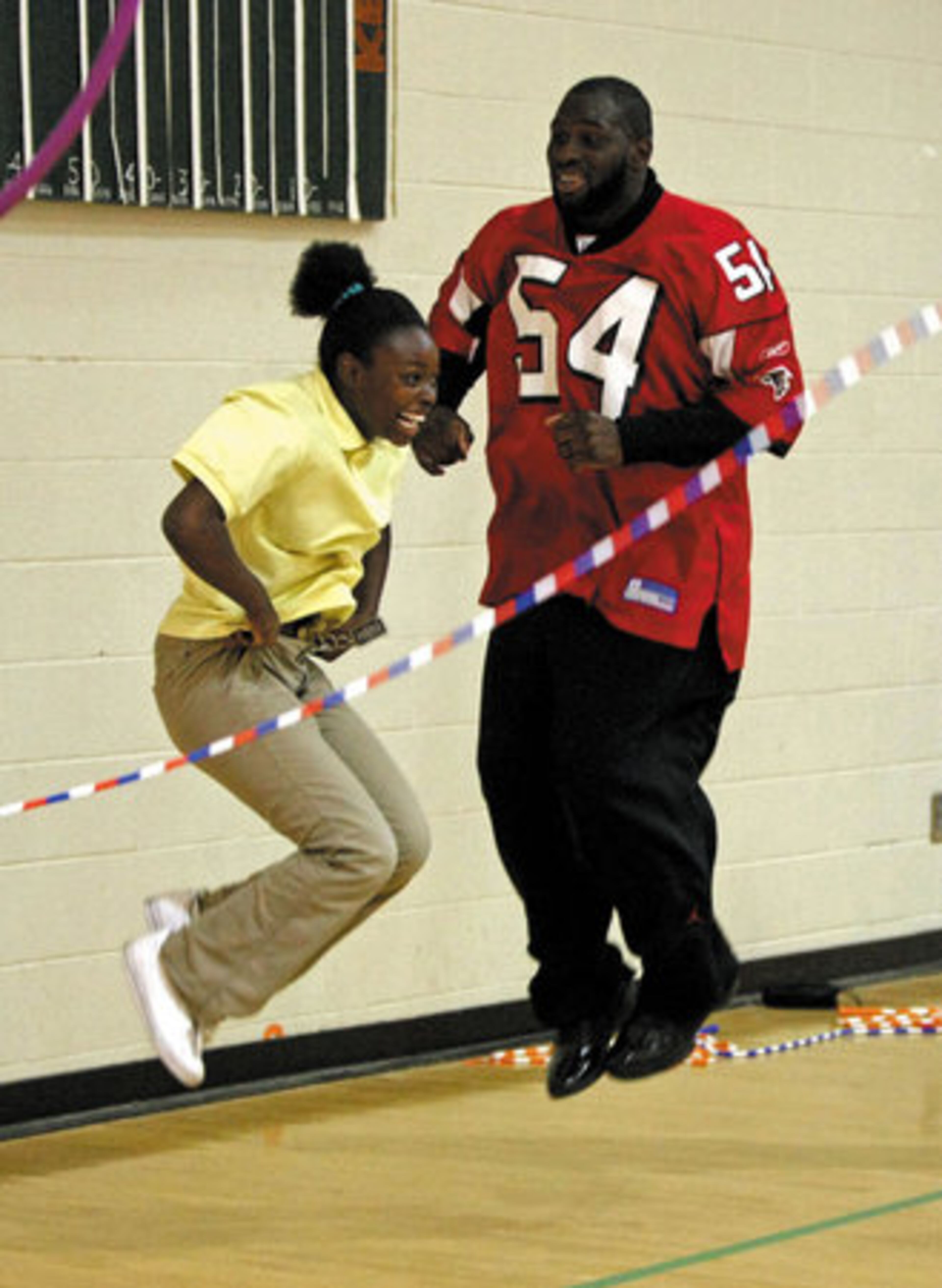 Several members of the Atlanta Falcons visited John F. Kennedy Middle School in Atlanta on Tuesday morning to promote physical fitness for kids. Here, linebacker Stephen Nicholas jumps rope with 7th grade student Hozeria Pierce.