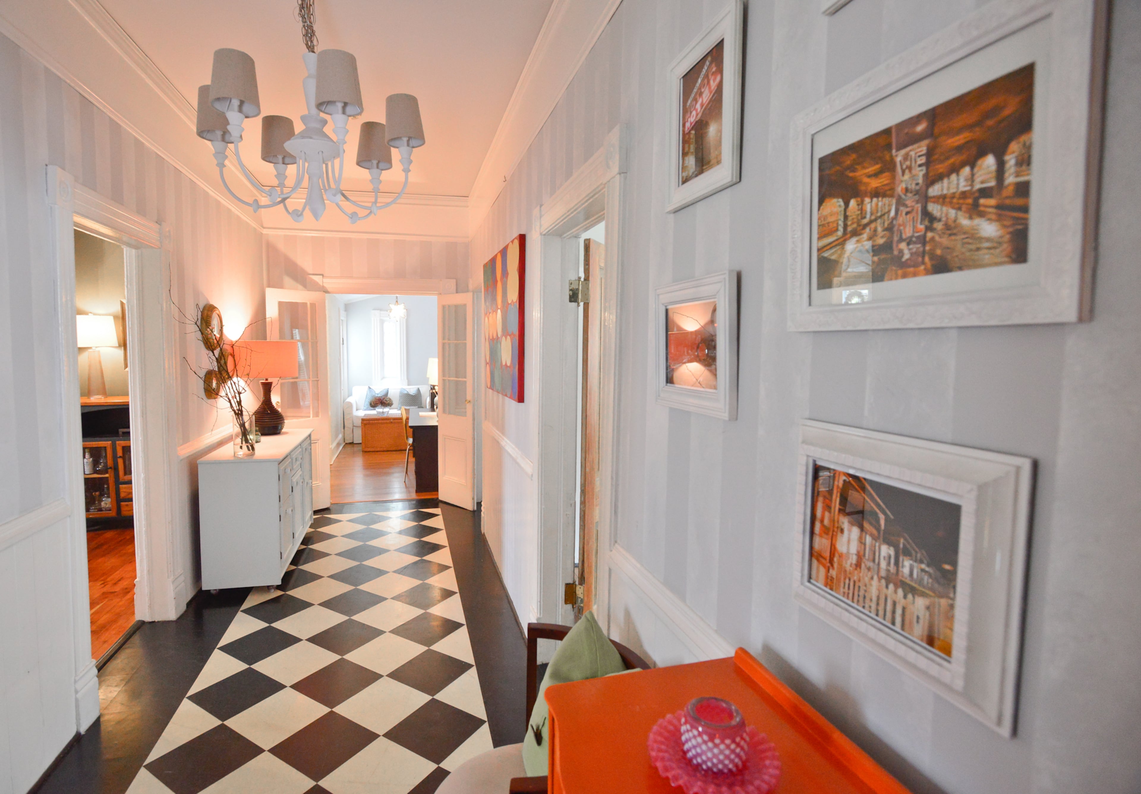 A roomy entryway welcomes visitors to Kendall and Nick Stowell's Victorian home, which was built in 1896. It's wide enough to accommodate two pieces that belonged to her grandparents and mid-century chairs. The black-and-white floor is made from a different material than the black-and-white ceramic tile in the kitchen, and the white light fixture is from West Elm.