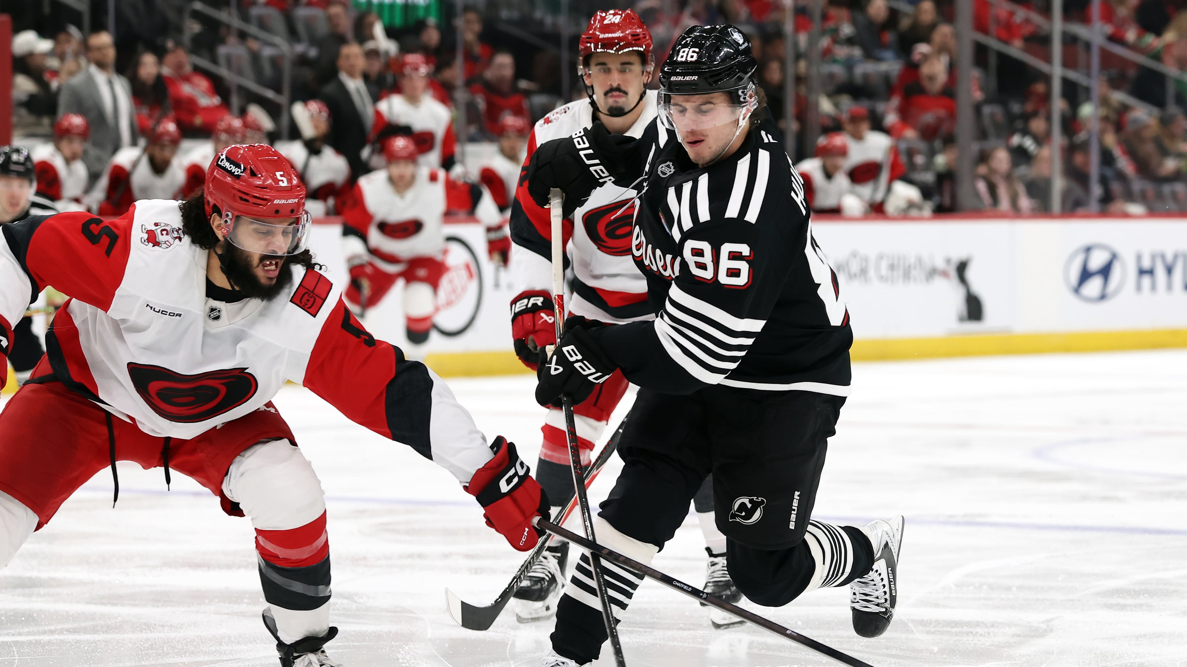 New Jersey Devils center Jack Hughes (86) has his shot knocked away by Carolina Hurricanes defenseman Jalen Chatfield (5) during the second period of an NHL hockey game Saturday, Jan. 17, 2026, in Newark, N.J. (AP Photo/Adam Hunger)