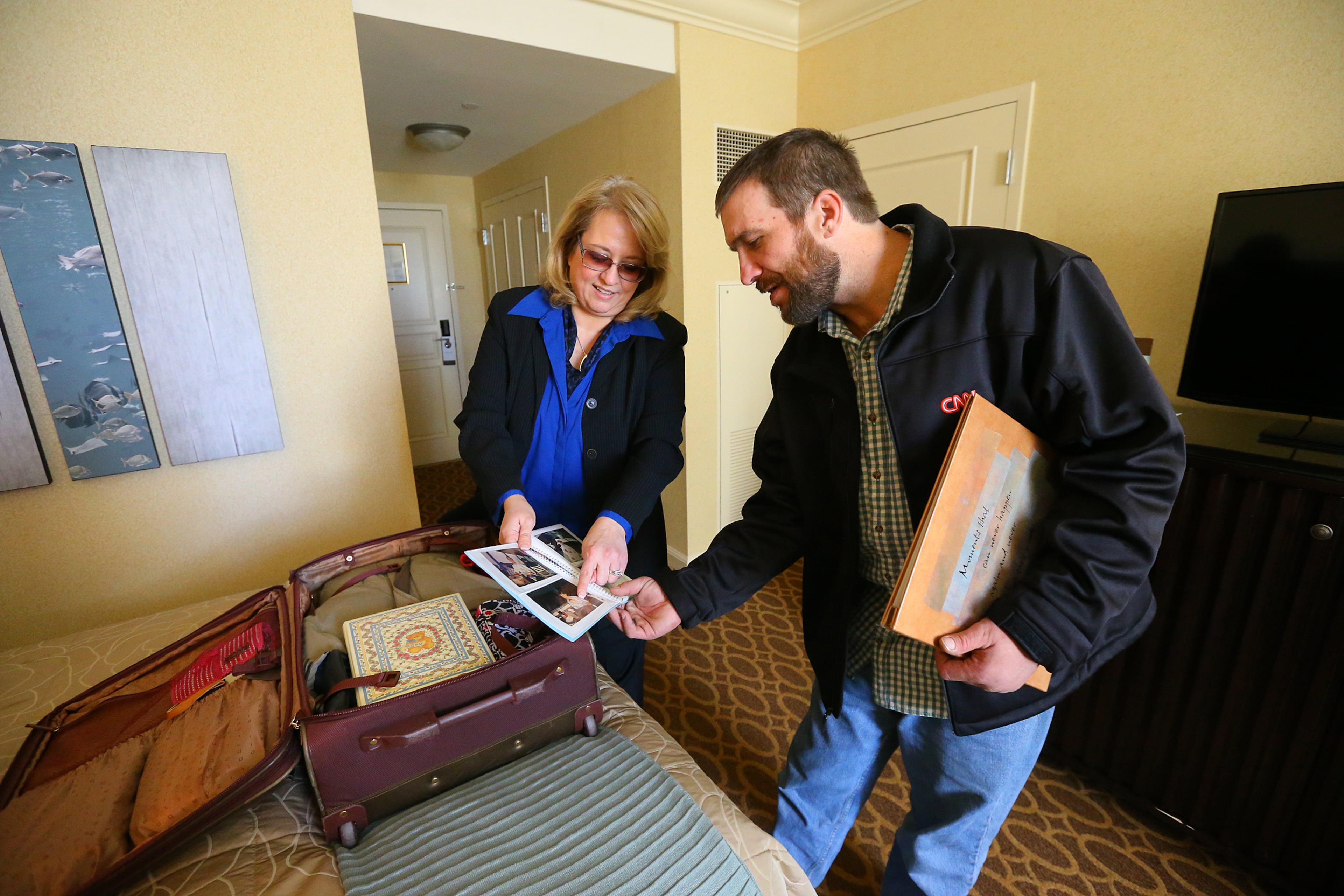 Back at the Omni Hotel at CNN Center stepmother Deanna Rodecki presents Joel Hartman gifts including family photo albums for him to keep. Rodecki has been searching for Hartman for more than a decade catching wind of him only to find he had moved on.