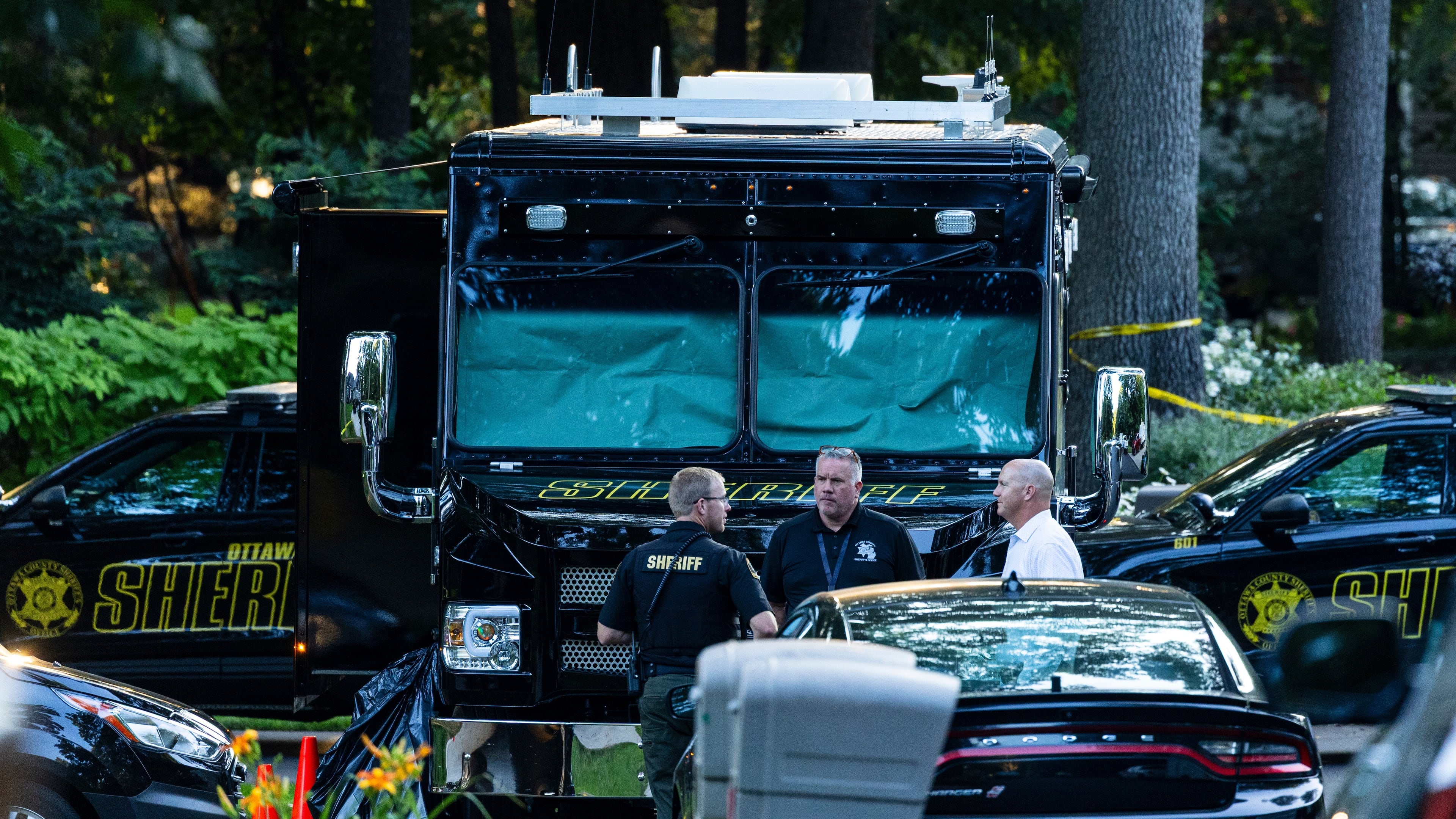 Law enforcement officials gather to investigate a fatal house fire on Friday, July 24, 2026, in Grand Haven Township, Mich. Ottawa County Sheriff's Office said six children and two adults were found dead in a "suspicious" house fire. (Joel Bissell/Kalamazoo Gazette via AP)