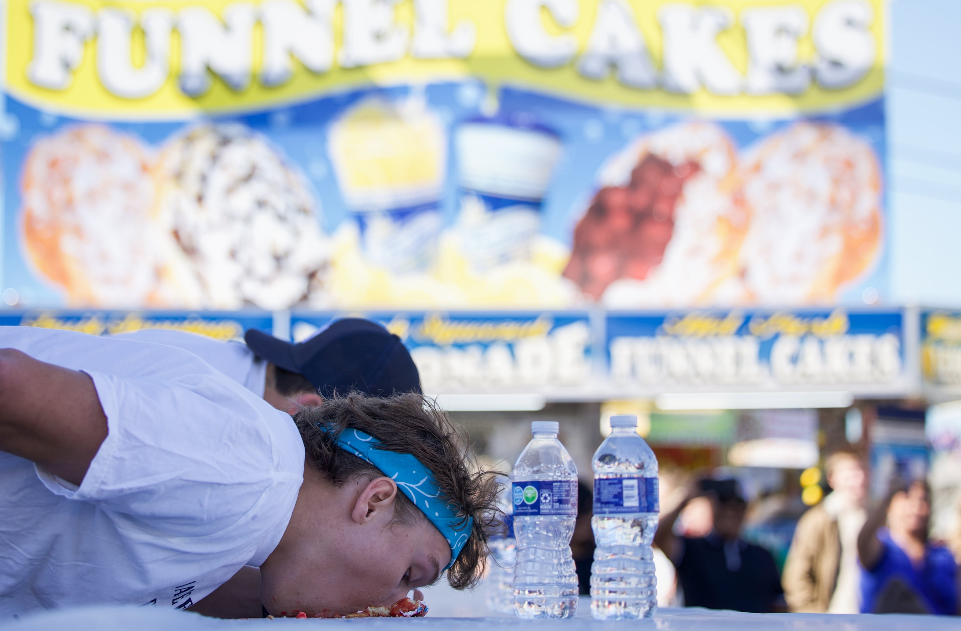 Jesse Dean, from Brunswick, Georgia, competes in the final round of the 2nd Annual Corn Dog Eating Competition at the Georgia National Fair in Perry, Georgia, on Oct. 17, 2026. Dean won the competition for the second year in a row, finishing off a bucket of mini donuts quickest without the use of hands. (Emily Laycock/UGA Photojournalism Workshop)