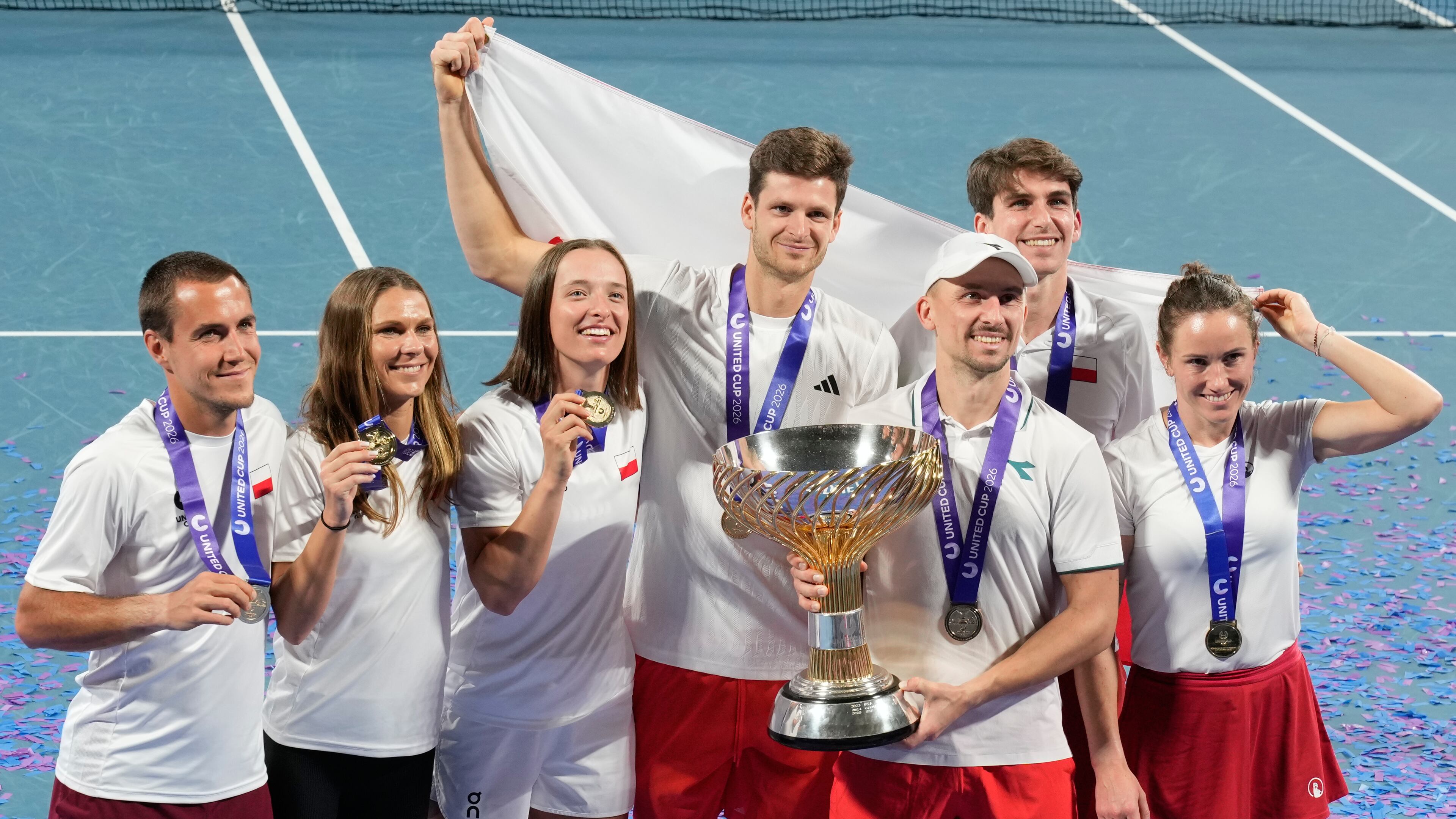 Teammembers from Poland celebrate with their trophy after defeating Switzerland in the final at the United Cup tennis tournament in Sydney, Monday, Jan. 12, 2026. (AP Photo/Rick Rycroft)