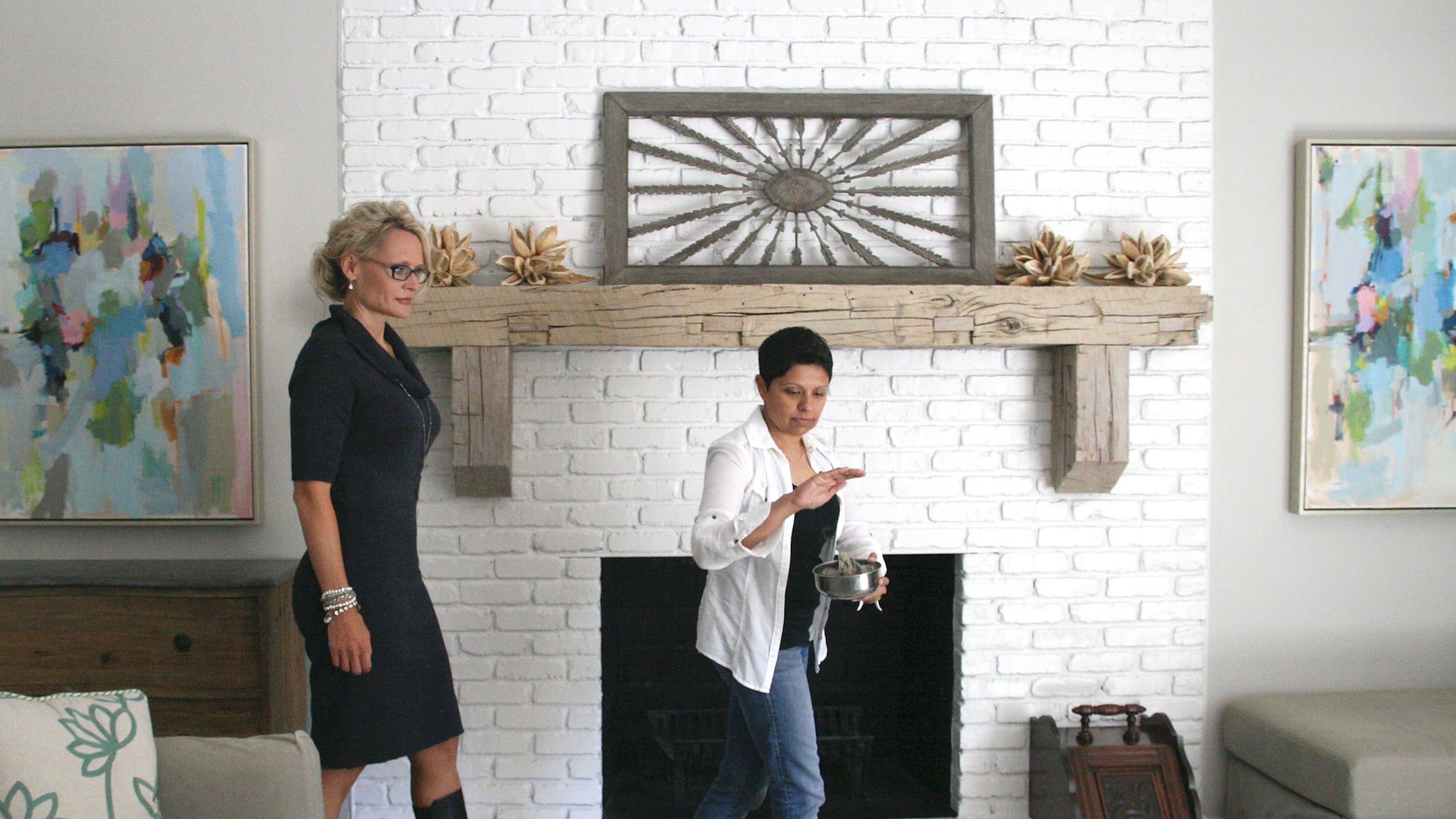 Real estate agent Collette McDonald (left) accompanies Reiki master and medium Darshana Patel through a house cleansing ritual. CREDIT: Stephanie Miller.