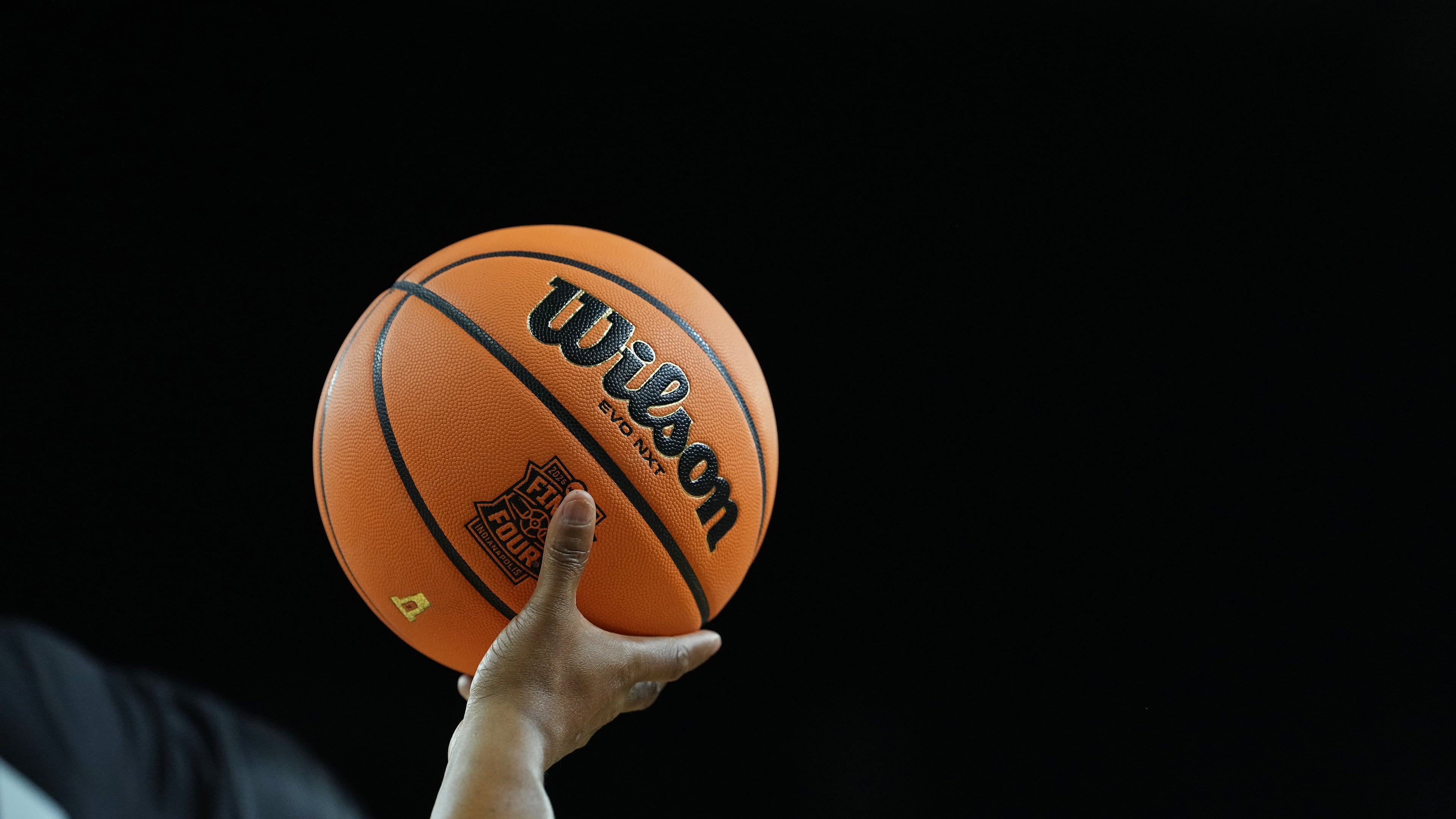 A official holds a ball during the first half of an NCAA college basketball tournament semifinal game between Arizona and Michigan at the Final Four, Saturday, April 4, 2026, in Indianapolis. (AP Photo/Michael Conroy)