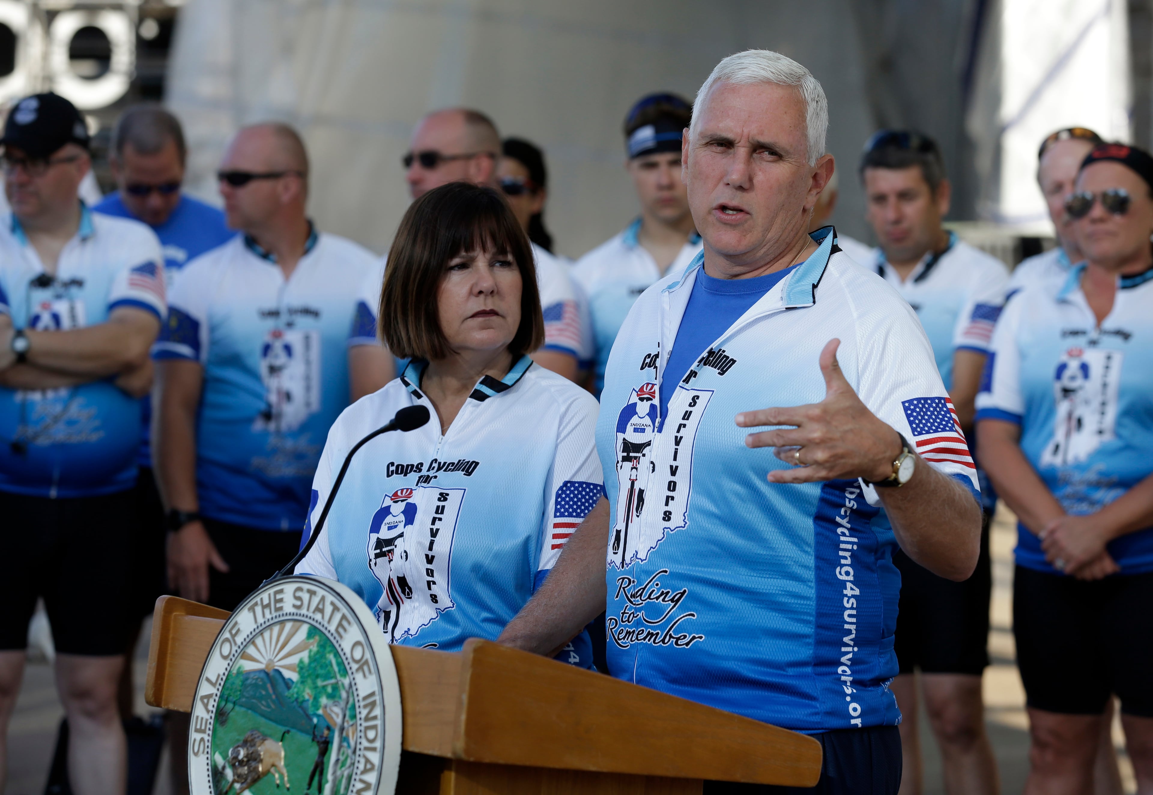 Indiana Gov. Mike Pence speaks as his wife Karen, looks on at the opening ceremony for the Cops Cycling for Survivors fundraising bike ride in Indianapolis, Monday, July 11, 2016. Pence is being considered as a possible running mate for GOP presidential nominee Donald Trump, who is expected to decide this week, and the two are expected to attend a fundraiser and rally together Tuesday evening. (AP Photo/Michael Conroy)