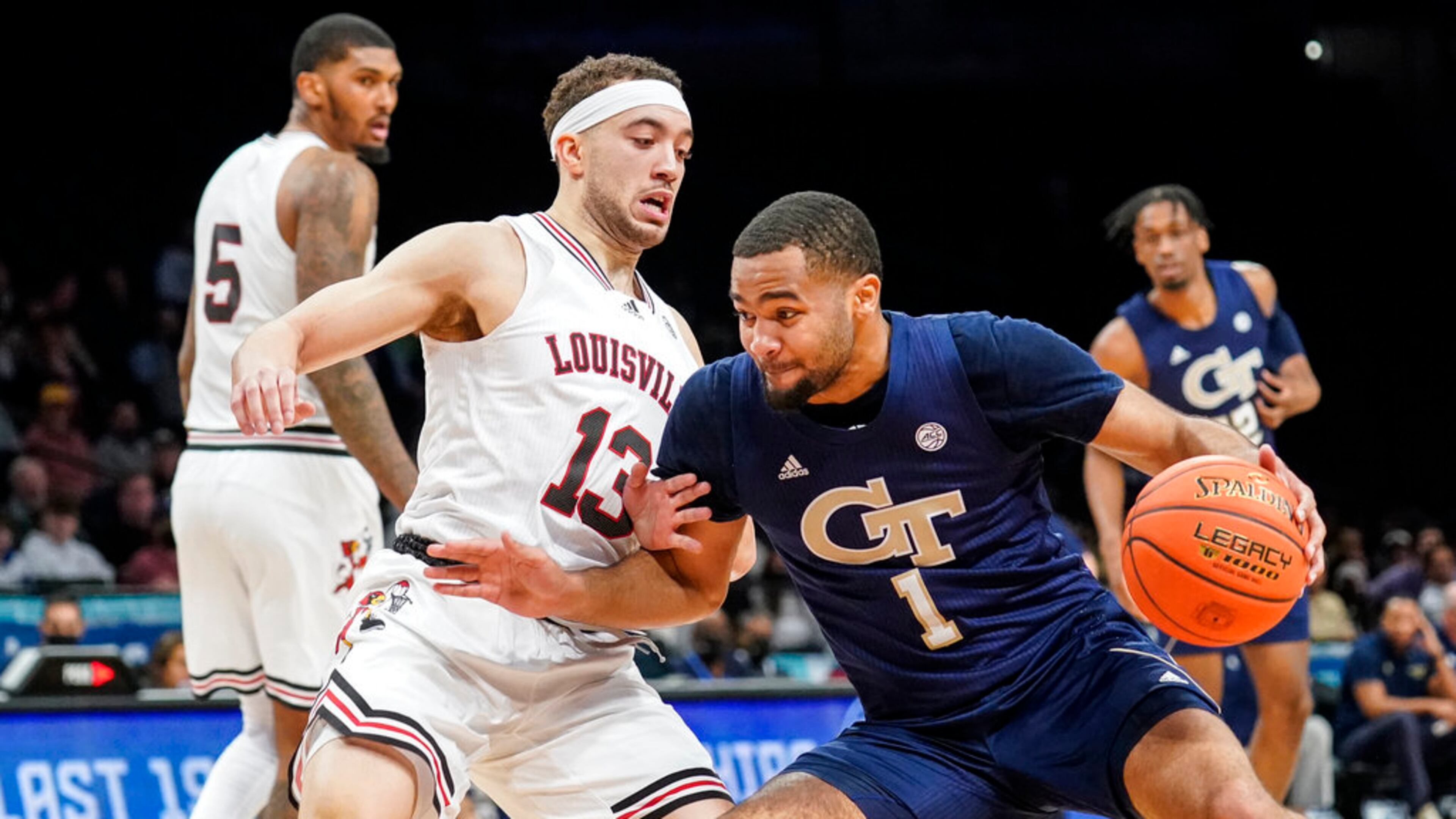 Georgia Tech's Kyle Sturdivant (1) drives against Louisville's Jarrod West (13) during the first half of an NCAA college basketball game of the Atlantic Coast Conference men's tournament, Tuesday, March 8, 2022, in New York. (AP Photo/John Minchillo)