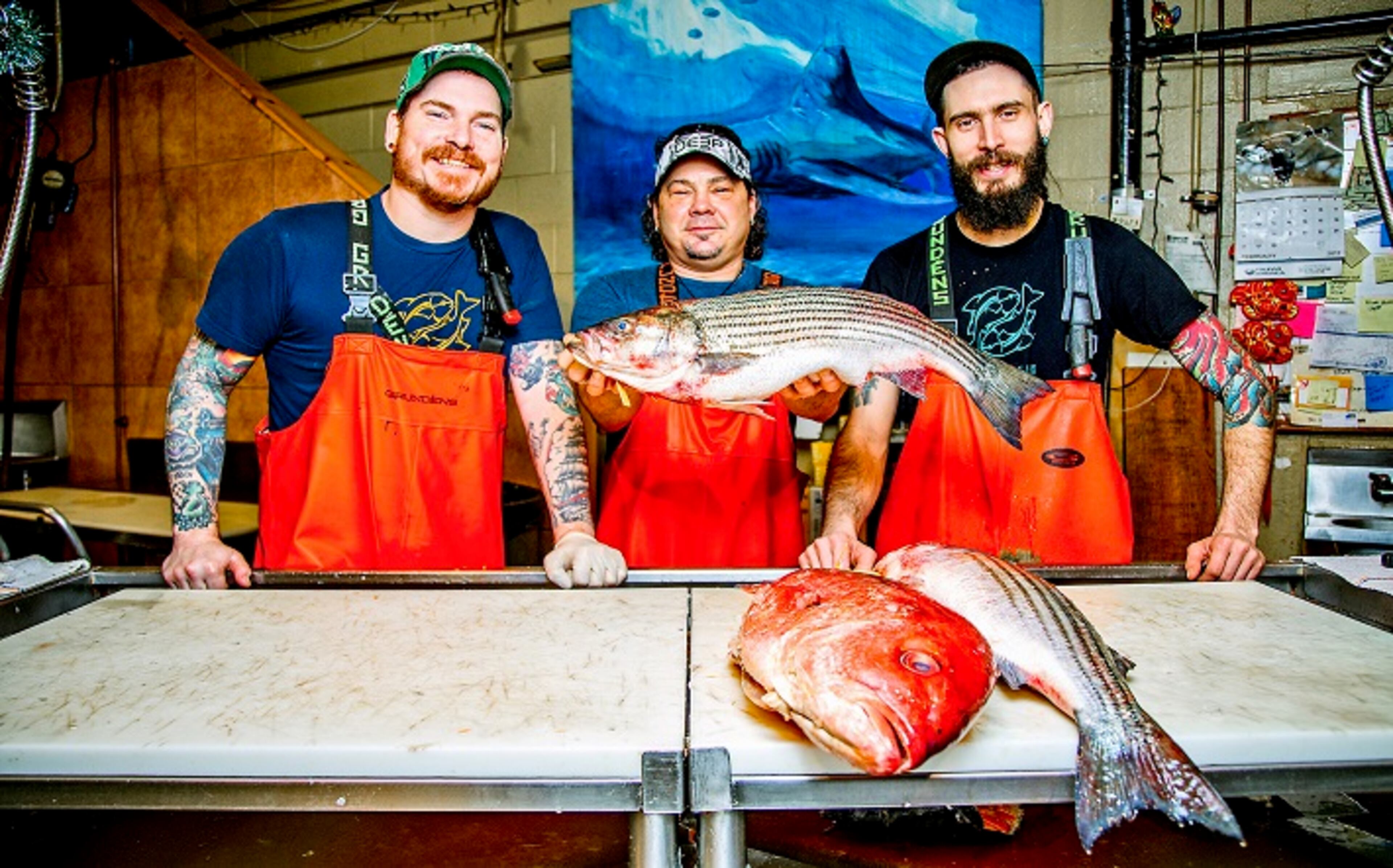 Tim Reynolds, senior fishmonger, Henry Dewey, owner, and Kyle Houghtelin, fishmonger, pose for a portrait behind the counter at Penn Avenue Fish Company in the Strip District. (Andrew Rush/Pittsburgh Post-Gazette/TNS)