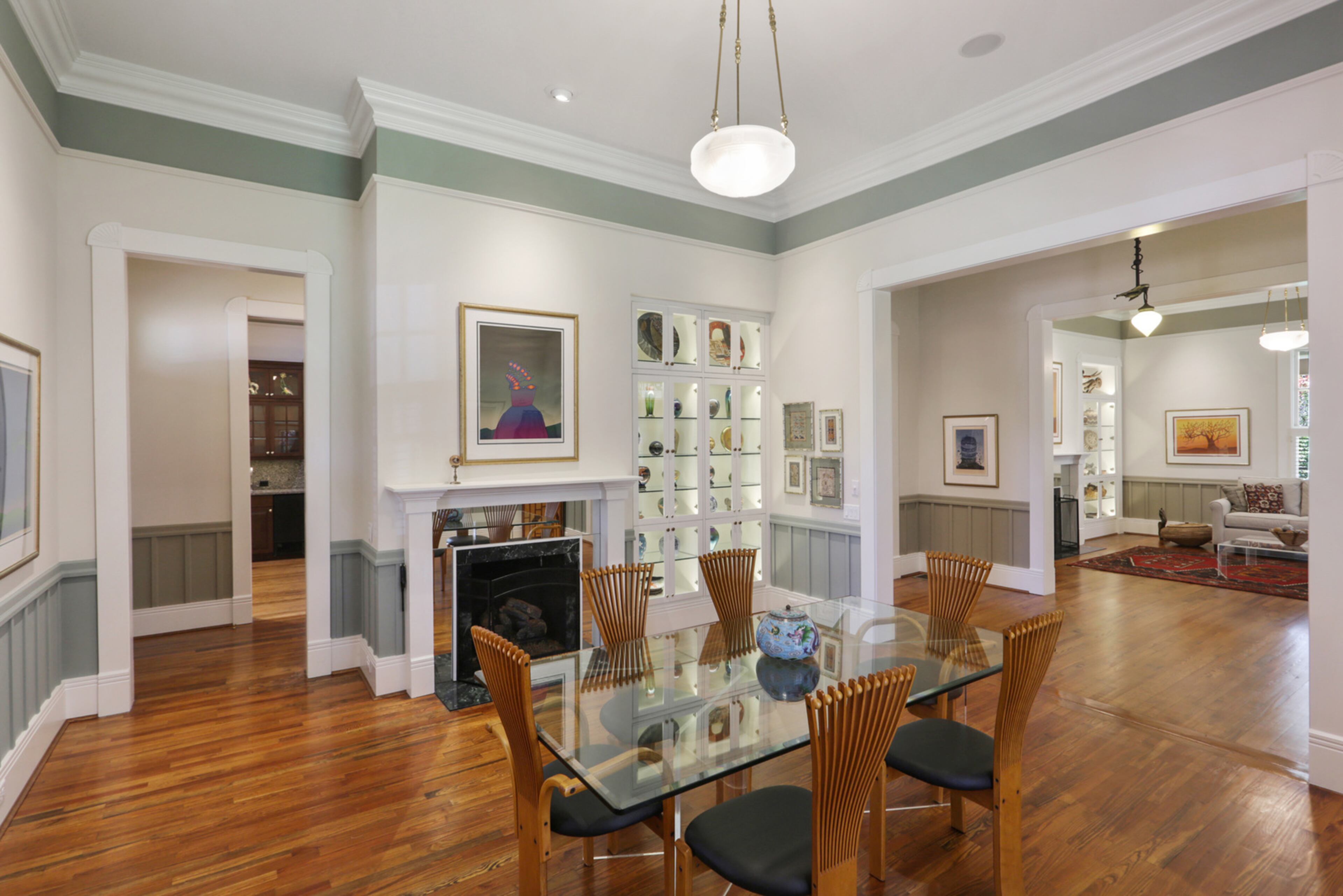 The dining area is on the other side of the front door, with another original fireplace and heart pine flooring. Both front rooms have custom built-in glass display cabinets. Text by Jill Huitron