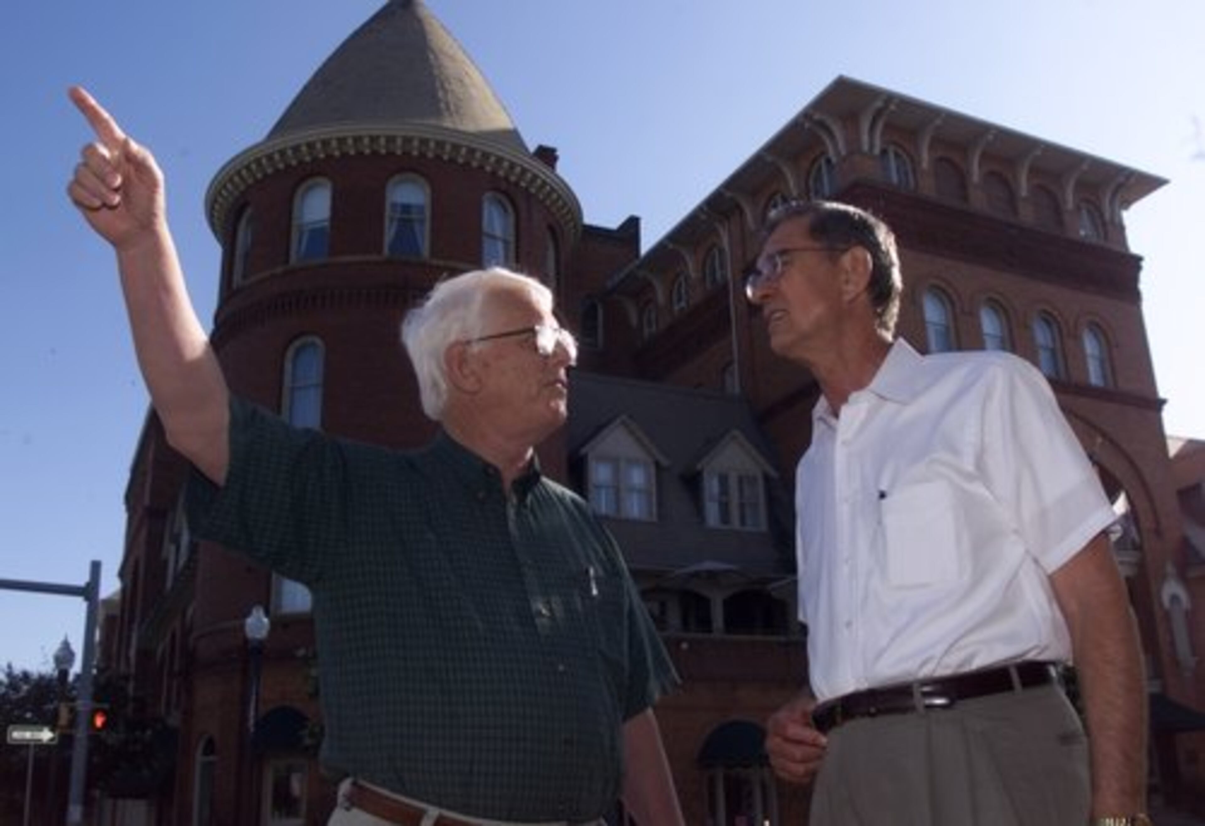 Americus Mayor Russell Thomas Jr. talks with Habitat founder Millard Fuller (right) in 2001 in front of the Windsor Hotel in downtown Americus. The renovation of the historic hotel in 1991 inspired Fuller to move Habitat International into an old Ford plant nearby and help with the downtown revitalization.