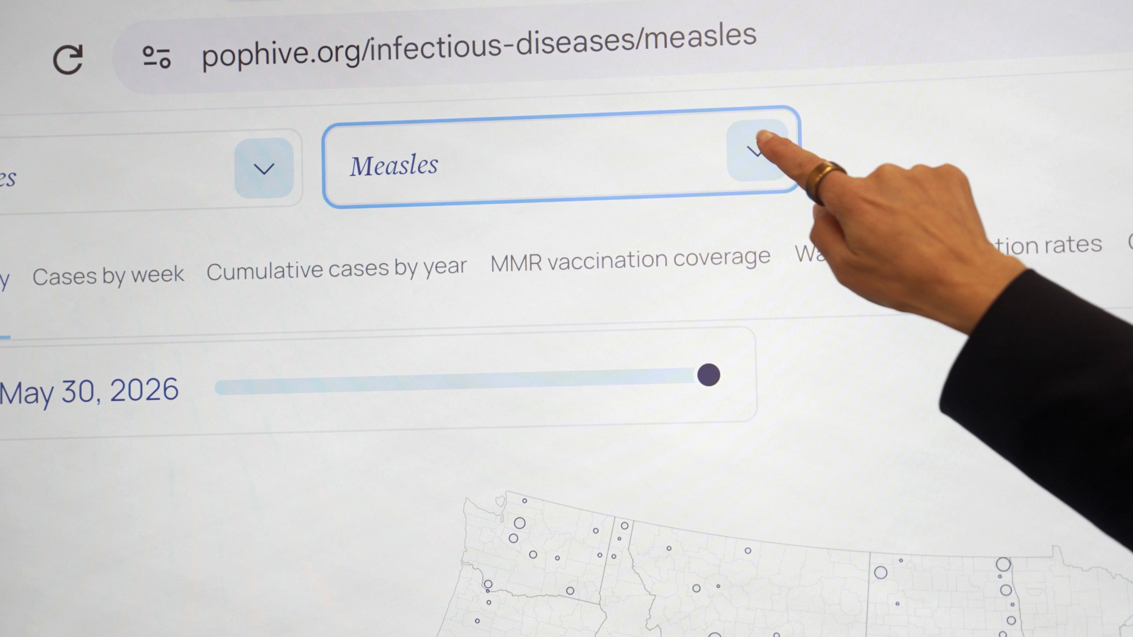 Georgetown University's Rebecca Katz points to measles data for the country at Georgetown's Health Security Operations Center in Washington on June 3, 2026. (AP Photo/Shelby Lum)