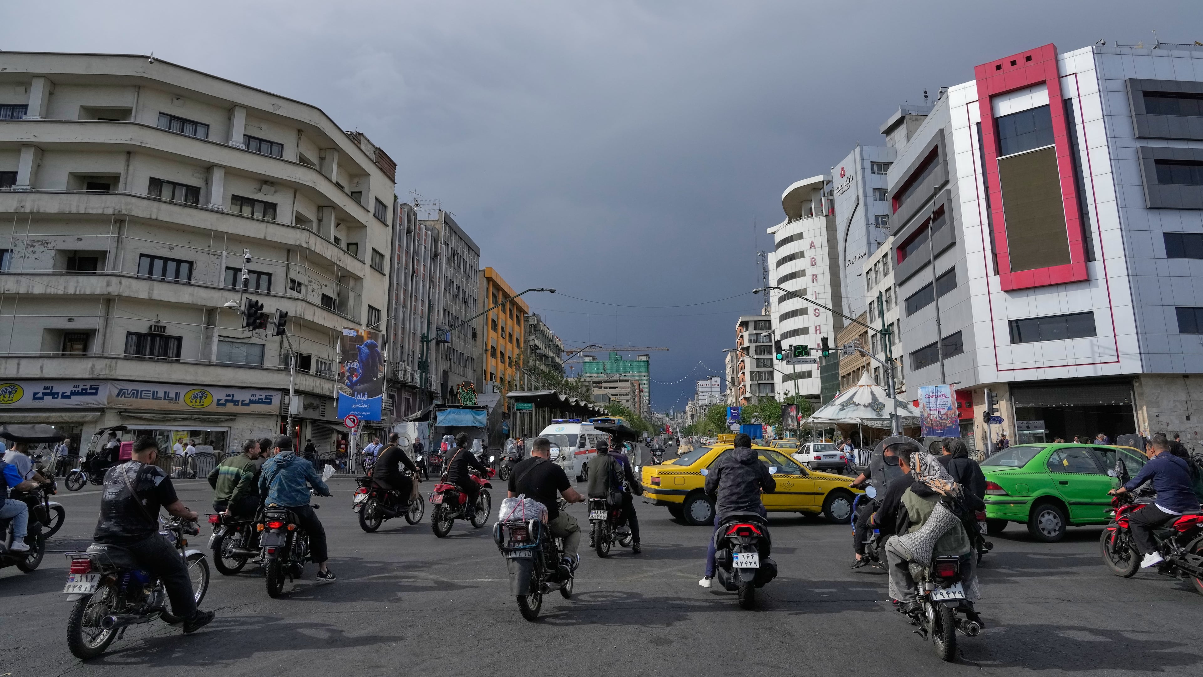 FILE - Motorbikes and cars pass through an intersection in downtown Tehran, Iran, May 17, 2026. (AP Photo/Vahid Salemi, File)