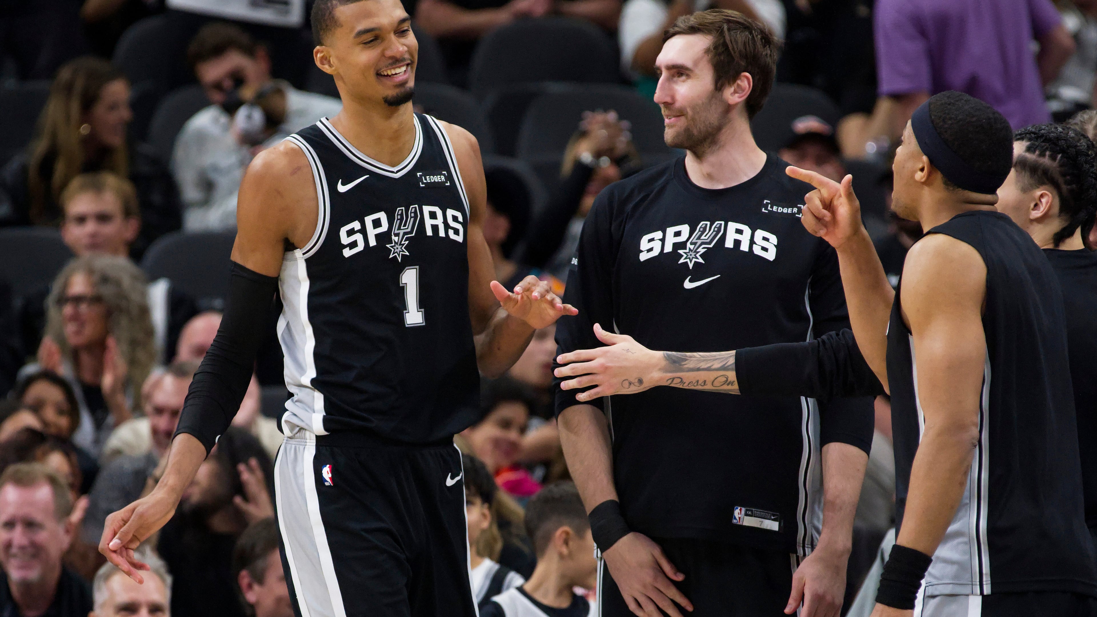 San Antonio Spurs center Victor Wembanyama (1) celebrates a basket with teammates Luke Kornet and Keldon Johnson, right, during the first half of their NBA basketball game against the Philadelphia 76ers, Monday, April 6, 2026, in San Antonio. (AP Photo/Darren Abate)