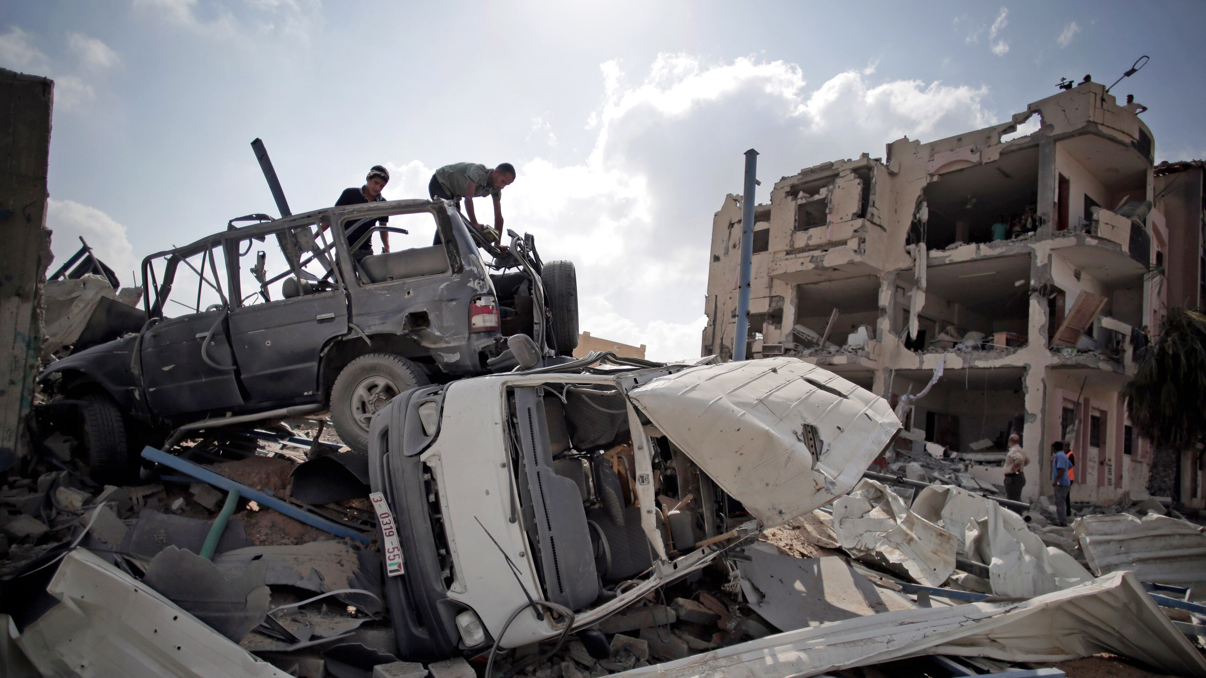 Palestinians search destroyed cars in Rafah's district of Shawkah in the southern Gaza Strip, Tuesday, Aug. 5, 2014. The attack at the Shawkah district east of the Gaza town of Rafah drew what was by far the heaviest shelling by the Israeli military in the Gaza war, killing nearly 100 people that day alone and instantly unraveling a three-day ceasefire shortly after it came into force. (AP Photo/Khalil Hamra) Palestinians search destroyed cars in Rafah's district of Shawkah in the southern Gaza Strip on Tuesday. The attack at the Shawkah district east of the Gaza town of Rafah drew what was by far the heaviest shelling by the Israeli military in the Gaza war, killing nearly 100 people that day alone and instantly unraveling a three-day ceasefire shortly after it came into force. AP/Khalil Hamra
