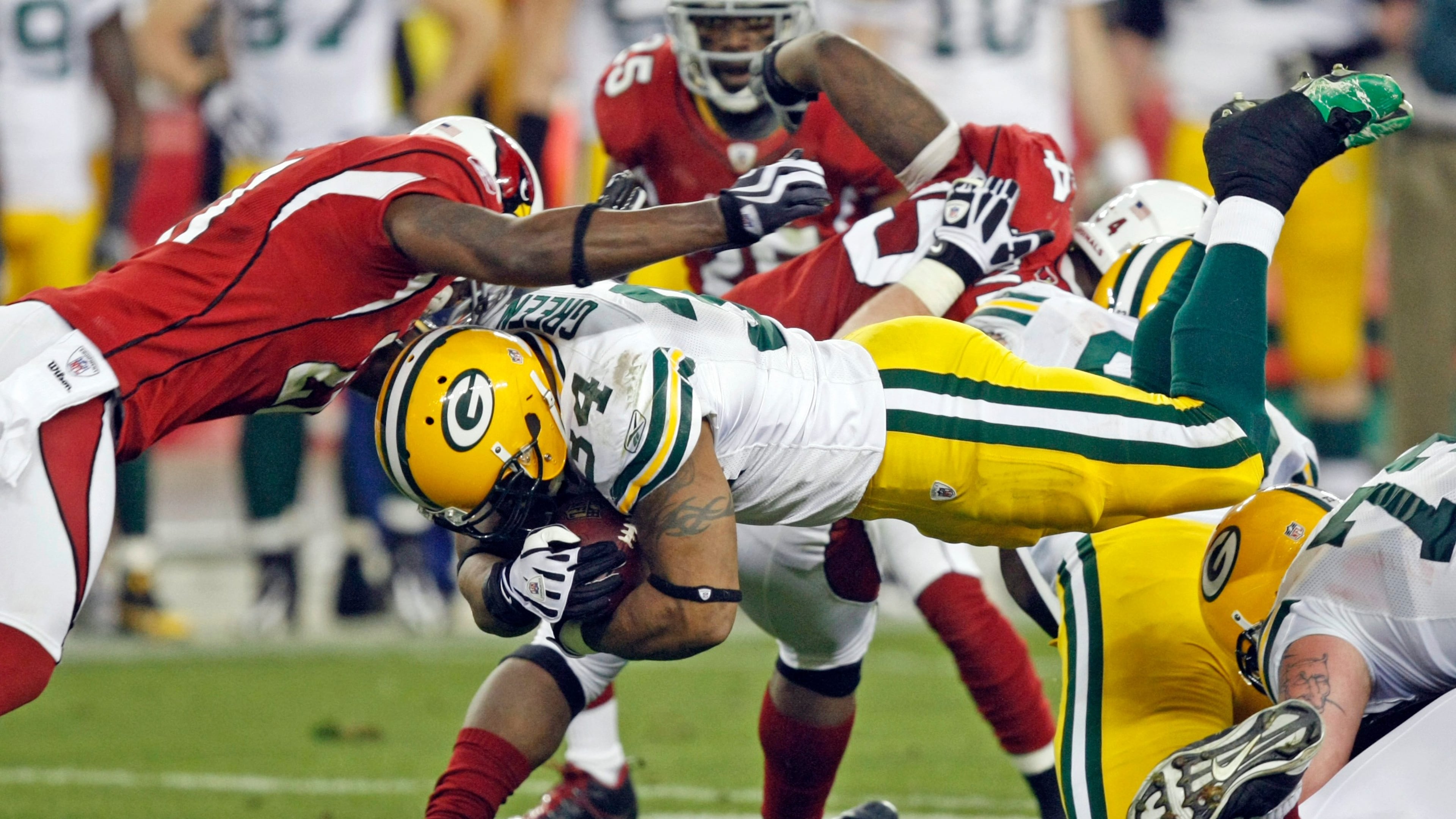 FILE - Green Bay Packers' Ahman Green (34) dives for a first down in front of Arizona Cardinals' Antrel Rolle (21) during the second half of an NFL wild-card playoff football game, Jan. 10, 2010, in Glendale, Ariz. (AP Photo/Matt York, File)