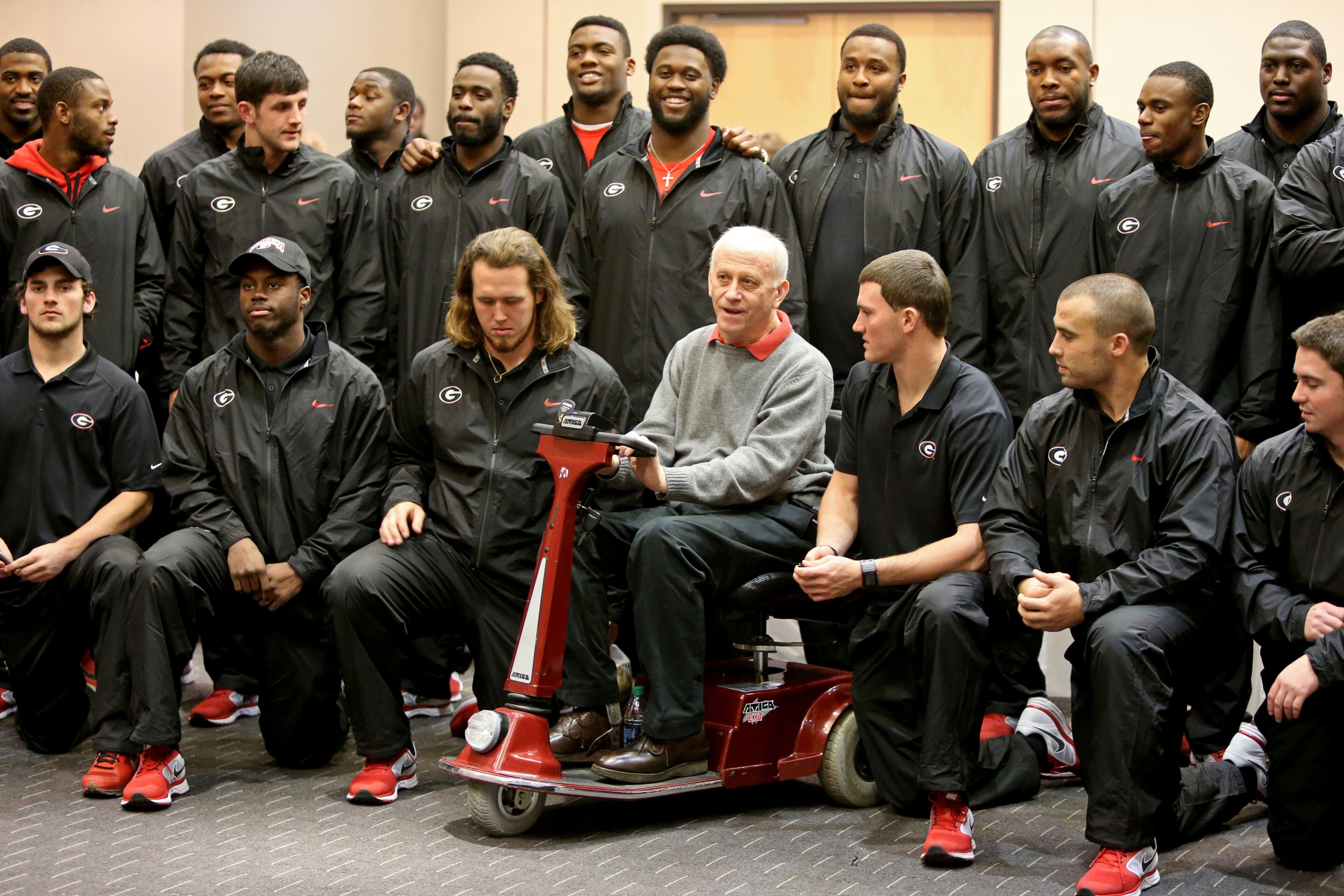 During a group photographs, James Shepherd, co-founder and chairman of the board of the Shepherd Center, talks with University of Georgia kicker Marshall Morgan (to the right of Shepherd) after a visit at the Shepherd Center the day before the Bulldogs' regular season finale at Georgia Tech Friday afternoon in Atlanta, Ga., November 29, 2013. Members of the University of Georgia defense and special teams visited the Shepherd Center. The Georgia football team split into two groups one visiting the Shepherd Center and the other visiting Children's Healthcare of Atlanta. The visits have become a tradition for the Bulldog team every other year when playing at Georgia Tech on Thanksgiving weekend.