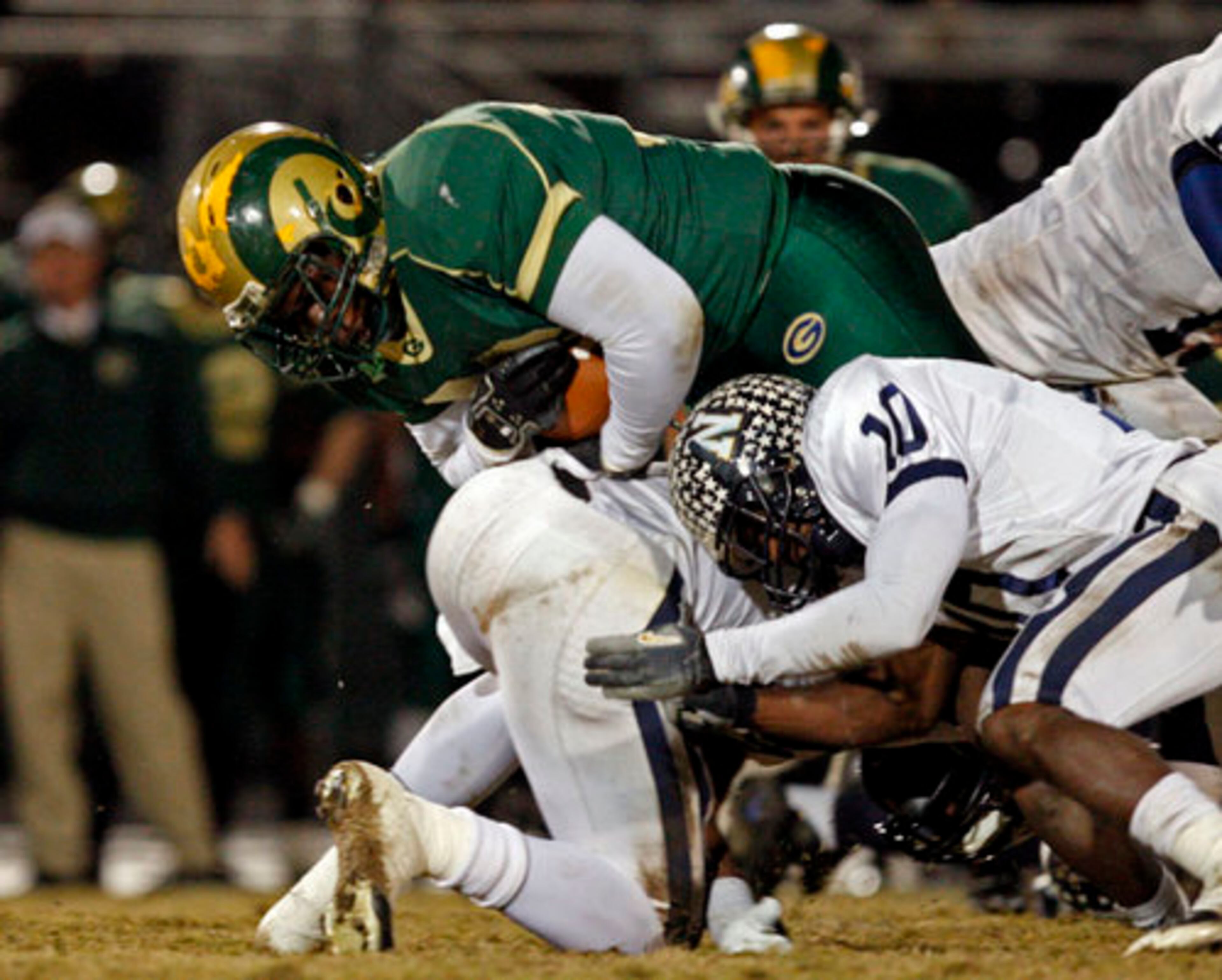 Grayson's Terry Williams (36) runs for a first down as Newnan defenders Alec Ogletree (39, center) and Jamal Ransby (10) attempt to slow down Williams.