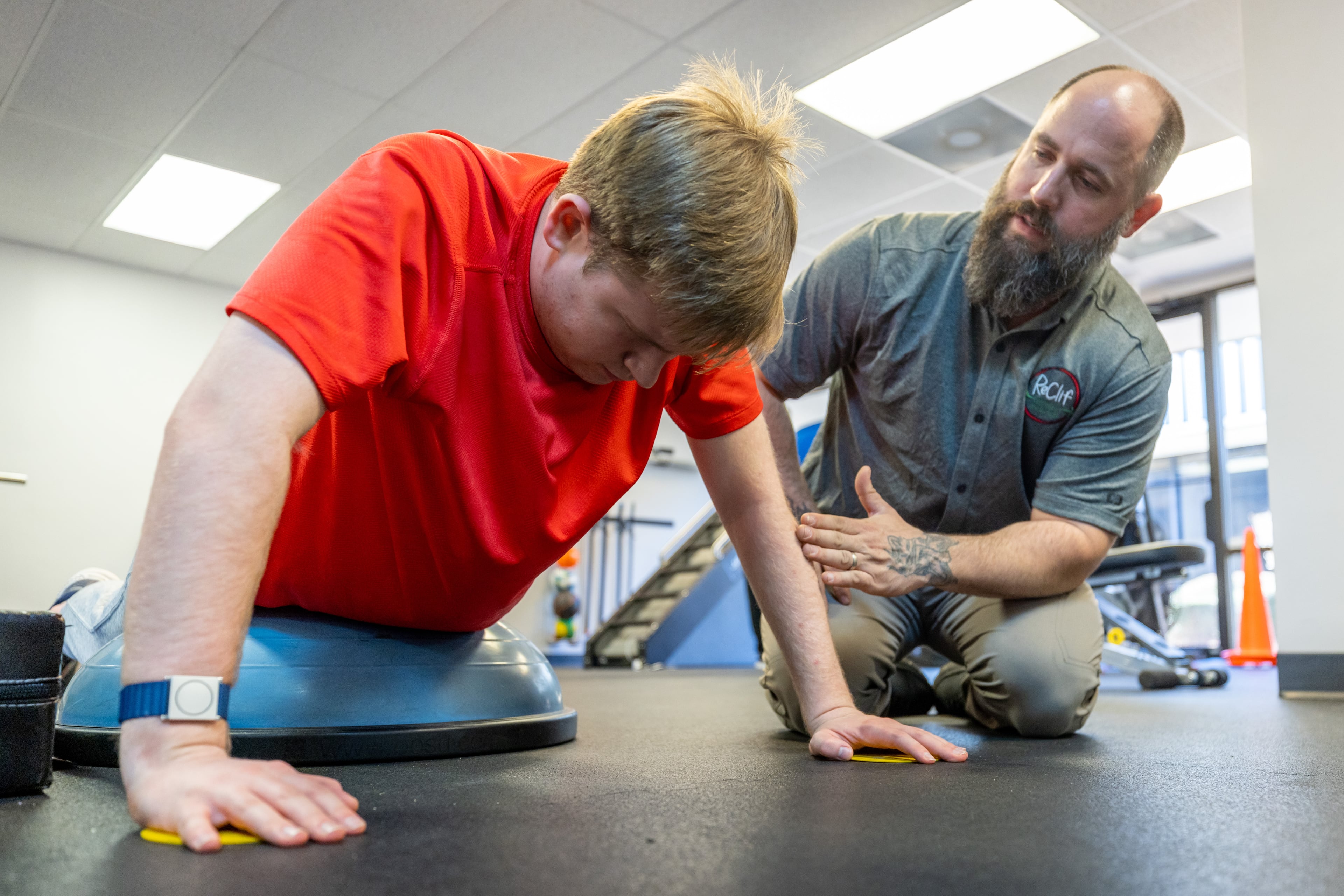Coach Dustin Dalton (right) works with Davis Manton at the ReClif fitness-based therapy center in Peachtree Corners Tuesday, Feb. 14, 2023. (Steve Schaefer/steve.schaefer@ajc.com)