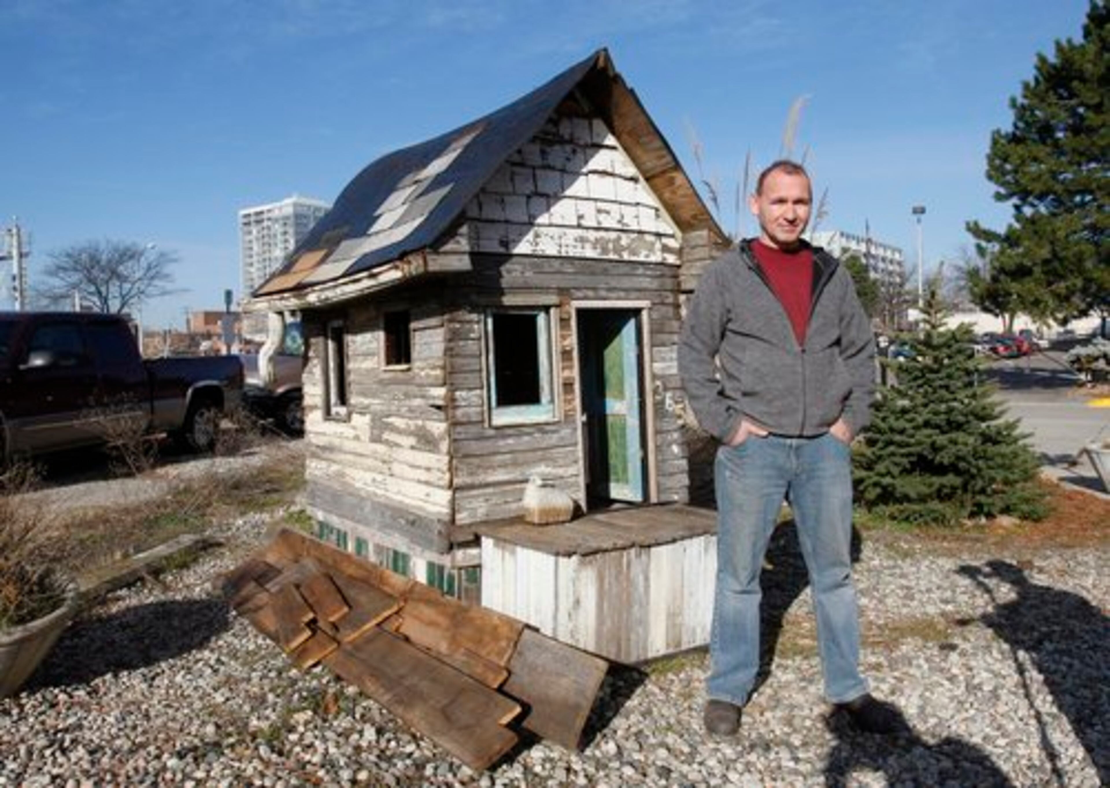 Richard Gage stands next to a miniature house built from the remnants of abandoned homes. The small house, created by artist Clinton Snider has become "a symbol for Detroit culture and how much abandonment there is, " said Snider.