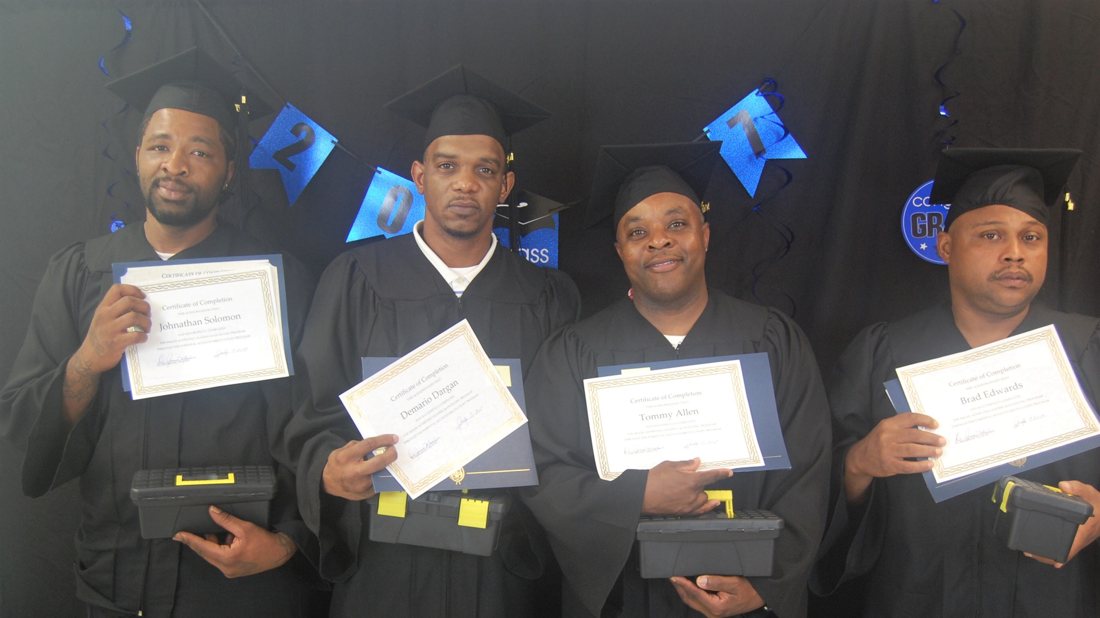 Four fathers — Johnathan Solomon, Demario Dargan, Tommy Allen and Brad Edwards — celebrate their completion of the Parental Accountability Court in Milledgeville, which gives parents the tools to make child support payments on time and keeps them out of jail. Courtesy photo.