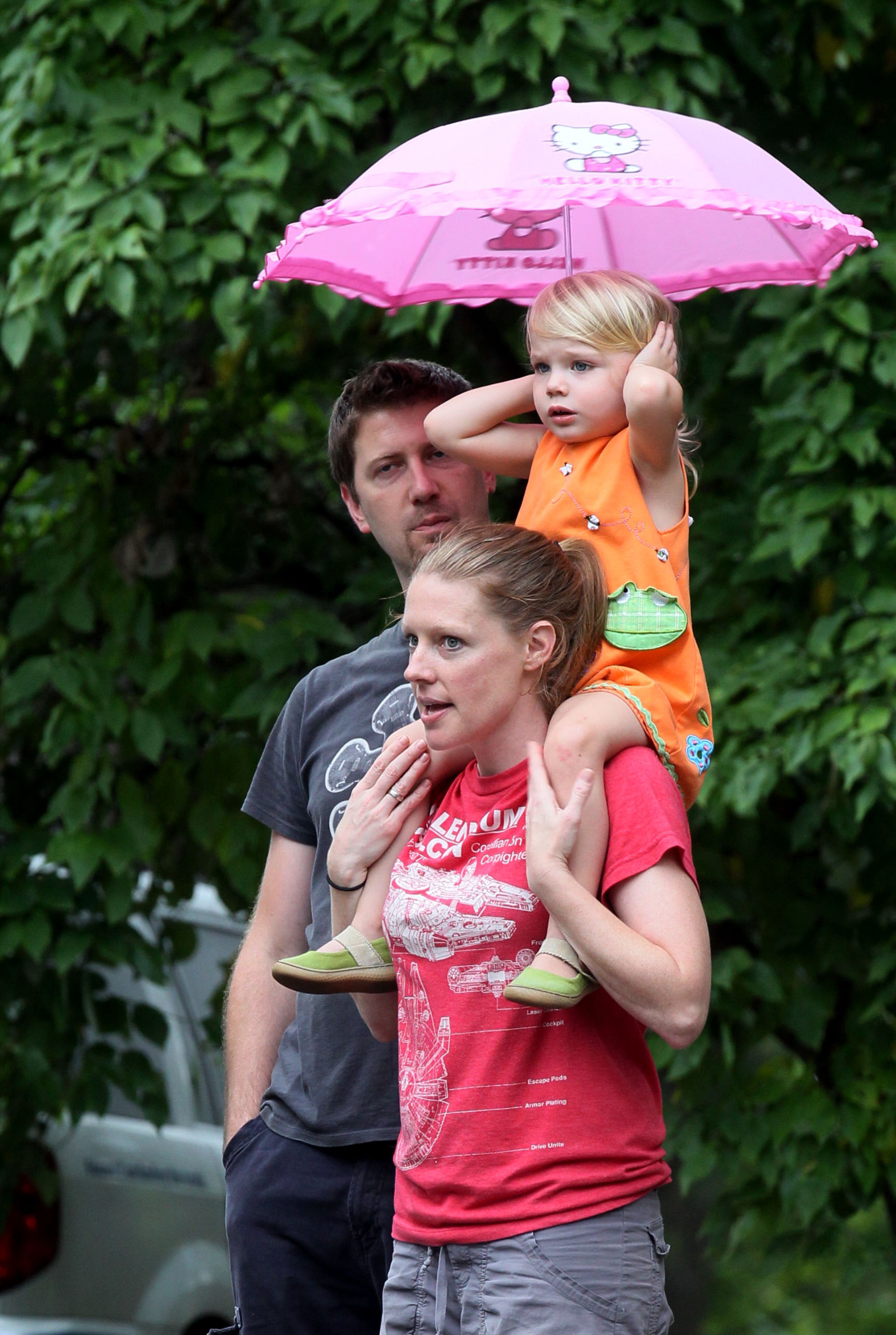 Three-year-old Mia Thorsen covered her ears because of the loud sirens while watching the neighborhood parade with her mother Kristin & Miro Malesevic at the Parkview Community Recreational Center in Atlanta during the 30th anniversary of National Night Out on Tuesday.