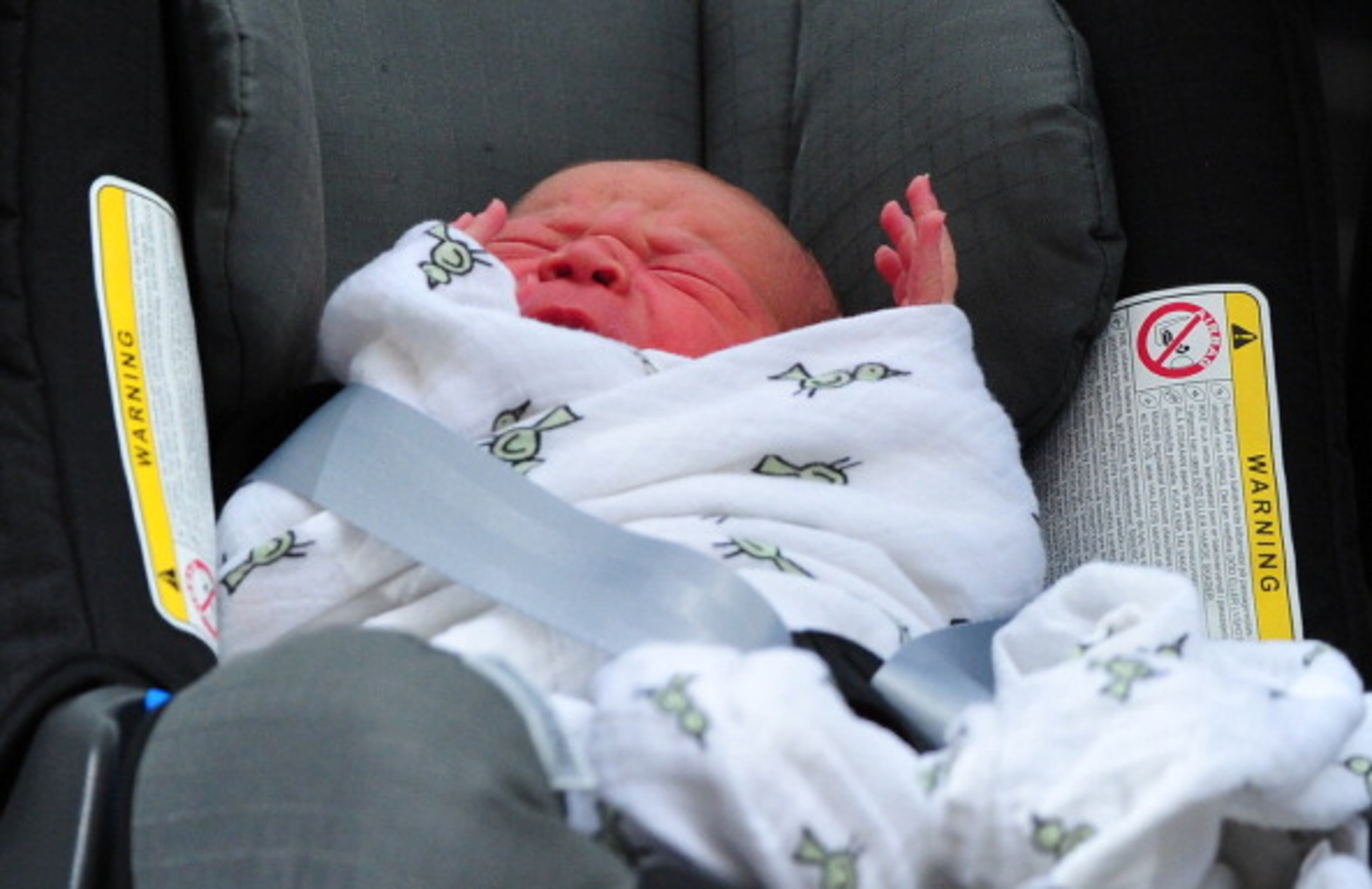 Prince William and Catherine, Duchess of Cambridge' new-born baby boy seen in a car seat outside the Lindo Wing of St Mary's Hospital in London on July 23, 2013. The baby was born on Monday afternoon weighing eight pounds six ounces (3.8 kilogrammes). The baby, titled His Royal Highness, Prince (name) of Cambridge, is directly in line to inherit the throne after Charles, Queen Elizabeth II's eldest son and heir, and his eldest son William. AFP PHOTO / CARL COURT (Photo credit should read CARL COURT/AFP/Getty Images)