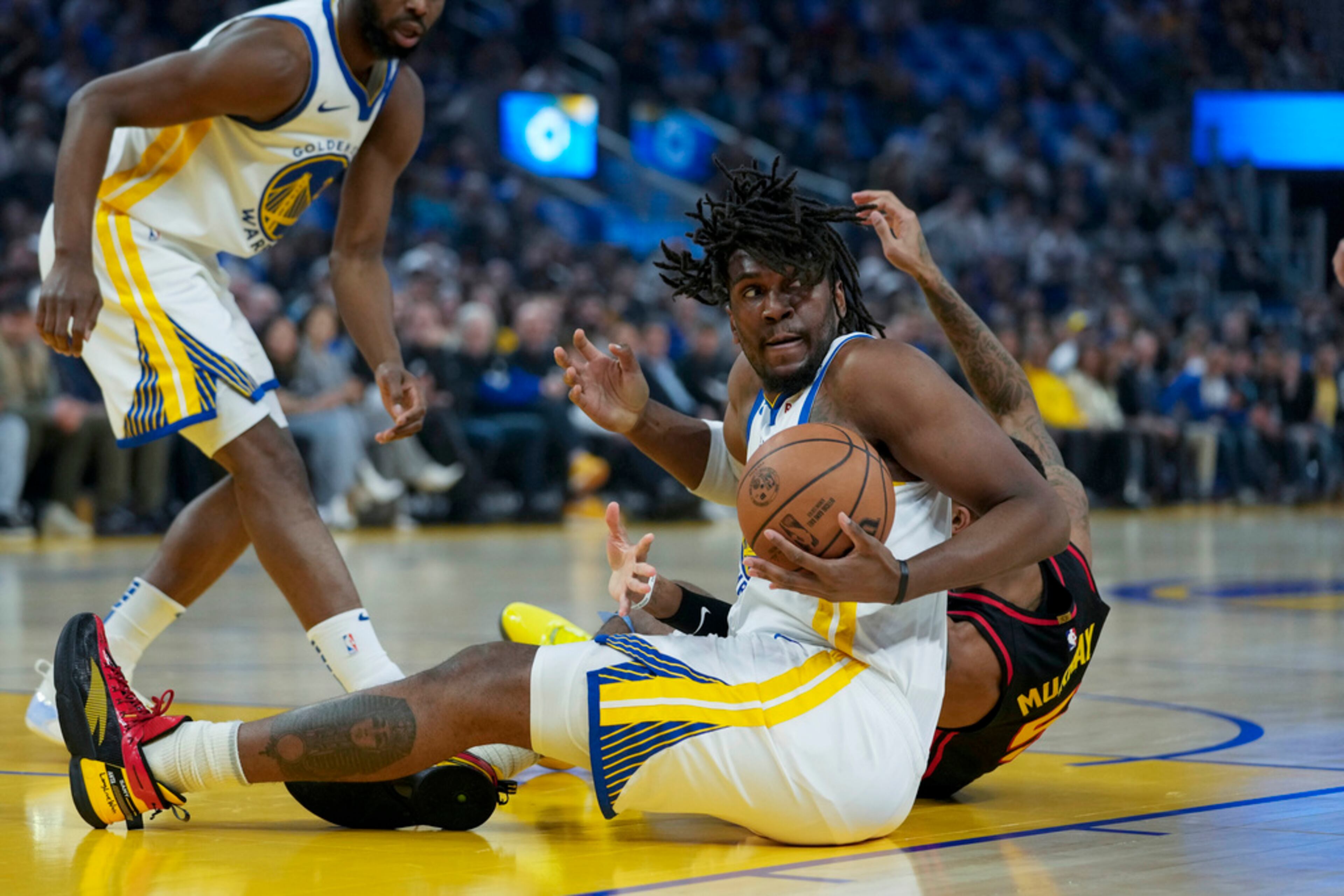 Golden State Warriors center Kevon Looney, center, takes the ball away from Atlanta Hawks guard Dejounte Murray, rear right, during the first half of an NBA basketball game, Wednesday, Jan. 24, 2024, in San Francisco. (AP Photo/Godofredo A. Vásquez)