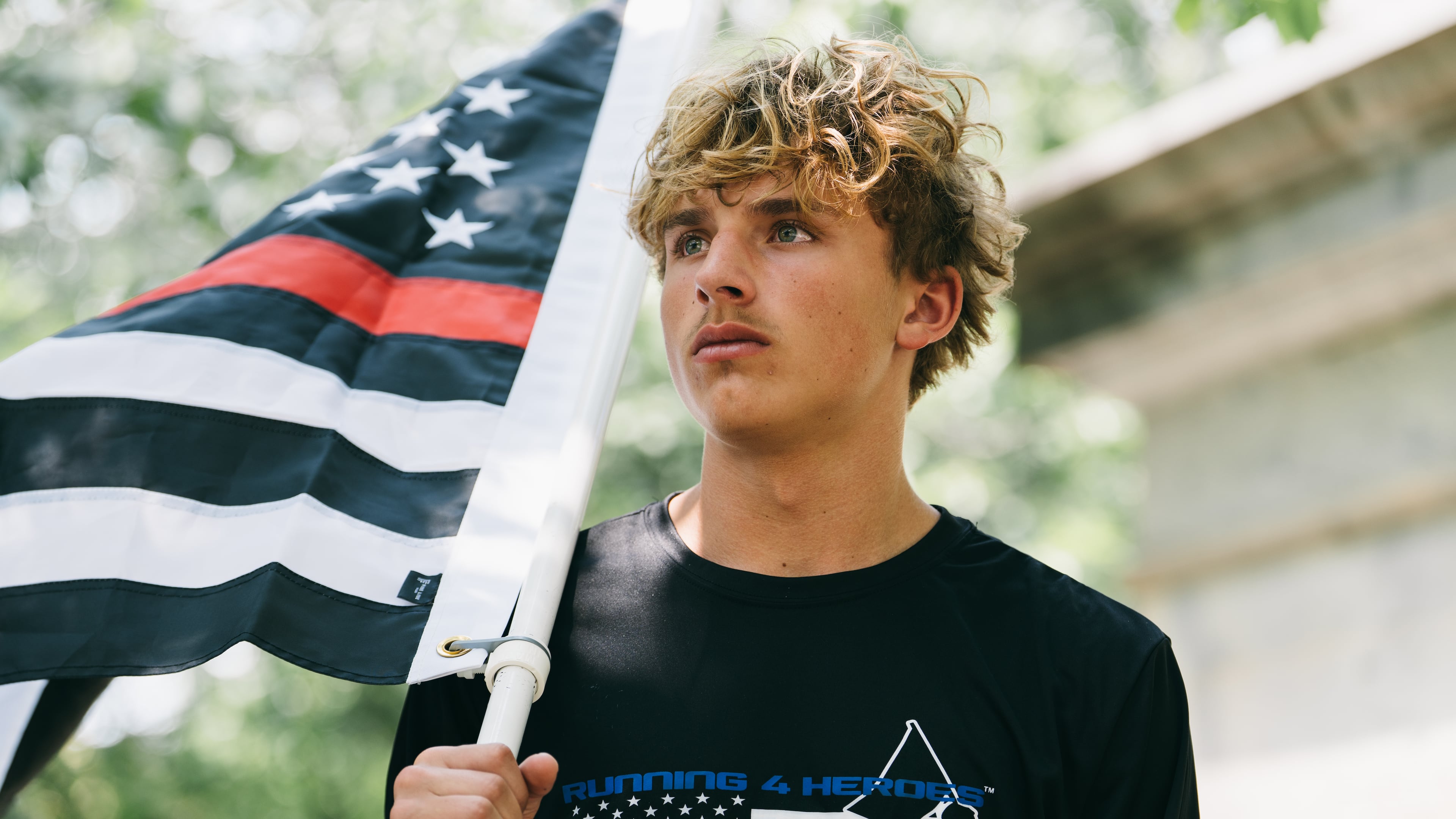 Andrew Collinson, 16, poses for a portrait in the Gainesville Square July 30, 2026, the day before he undertakes his final run for the nonprofit Running 4 Heroes Inc. Collinson has run over 130 miles for the organization, honoring first responders whose lives have been lost in service (Olivia Bowdoin for the AJC).