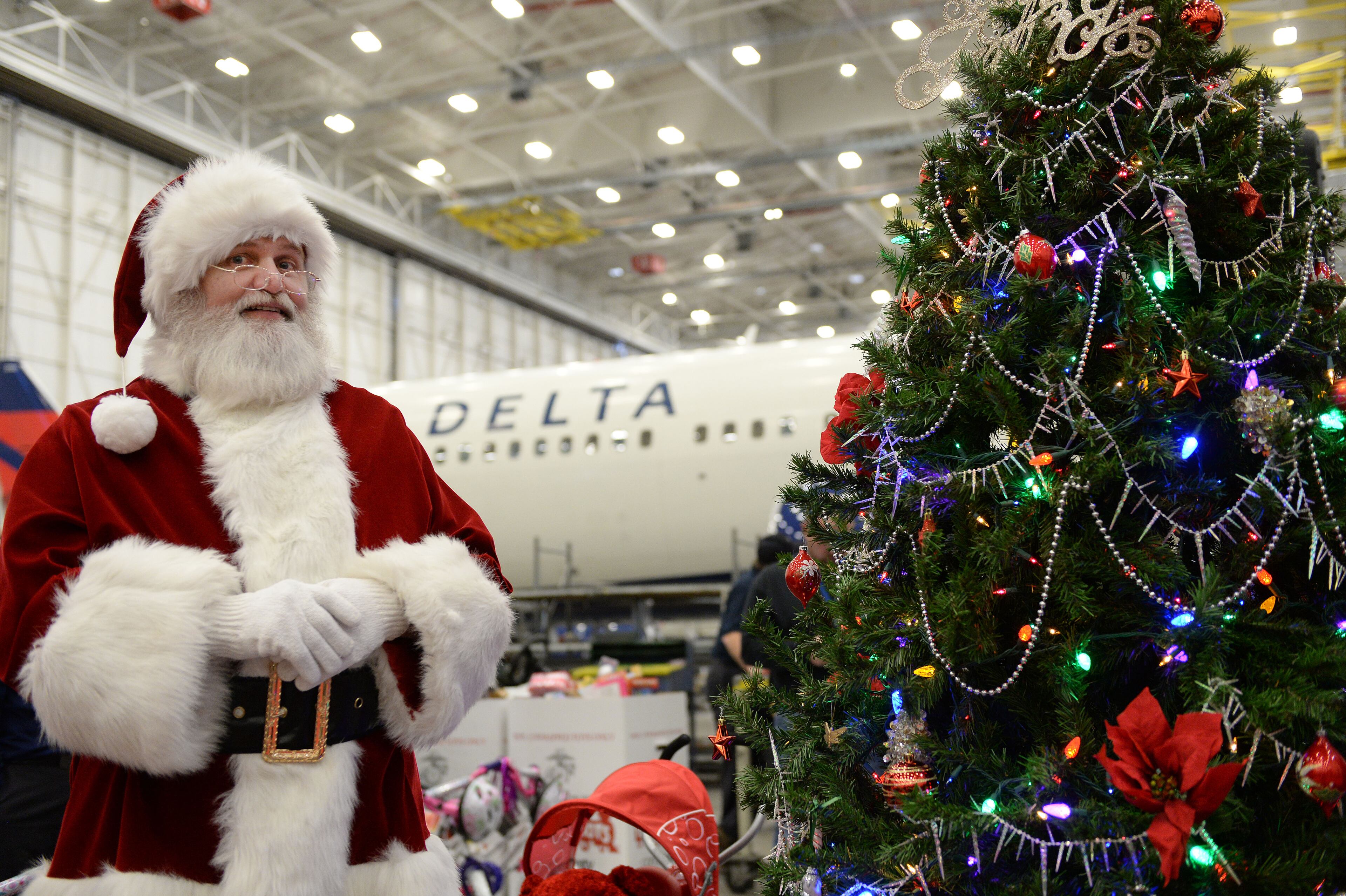 DECEMBER 4, 2015 ATLANTA Santa (Wayne Chase) listens to remarks during the program. Technicians at Delta's TechOps maintenance operation donated nearly 700 bikes (with helmets) to Marine Corps representatives Friday, December 4, 2015. Marine Corps Col Matt Puglisi, Commanding Officer, Combat Logistics Regiment 45, accepted the bikes, that were donated and assembled by Delta technicians, who work in 21 different shops, each specializing in an area like avionics, wheels and brakes, engines and airframes. There were also 2,500 toys donated. This is the 11th year TechOps has donated bicycles and toys. KENT D. JOHNSON/ kdjohnson@ajc.com