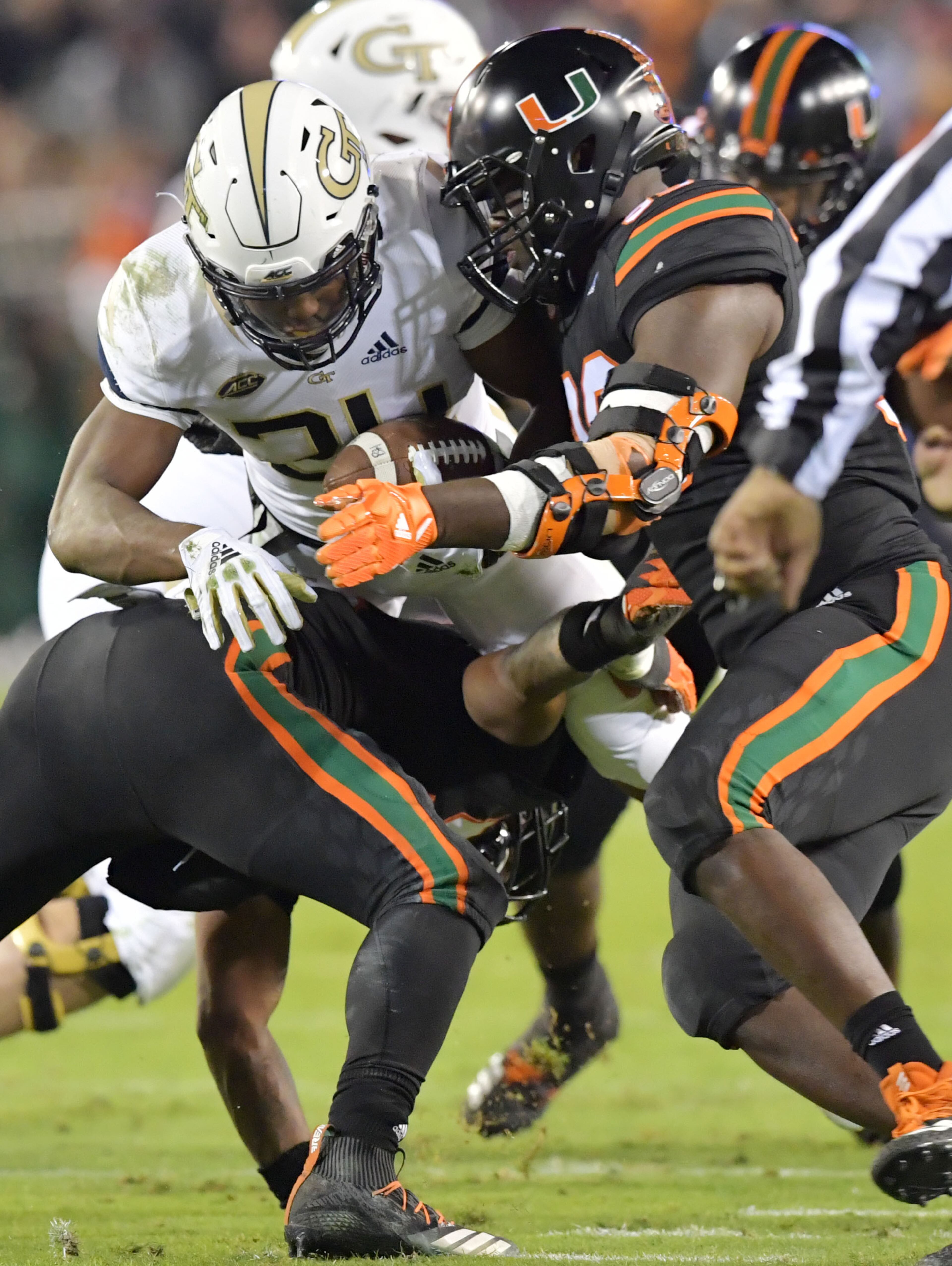 November 10, 2018 Atlanta - Georgia Tech running back Jordan Mason (24) is stopped by Miami linebacker Michael Pinckney (56) and Miami defensive lineman Joe Jackson (99) in the first half at Bobby Dodd Stadium on Saturday, November 10, 2018. HYOSUB SHIN / HSHIN@AJC.COM