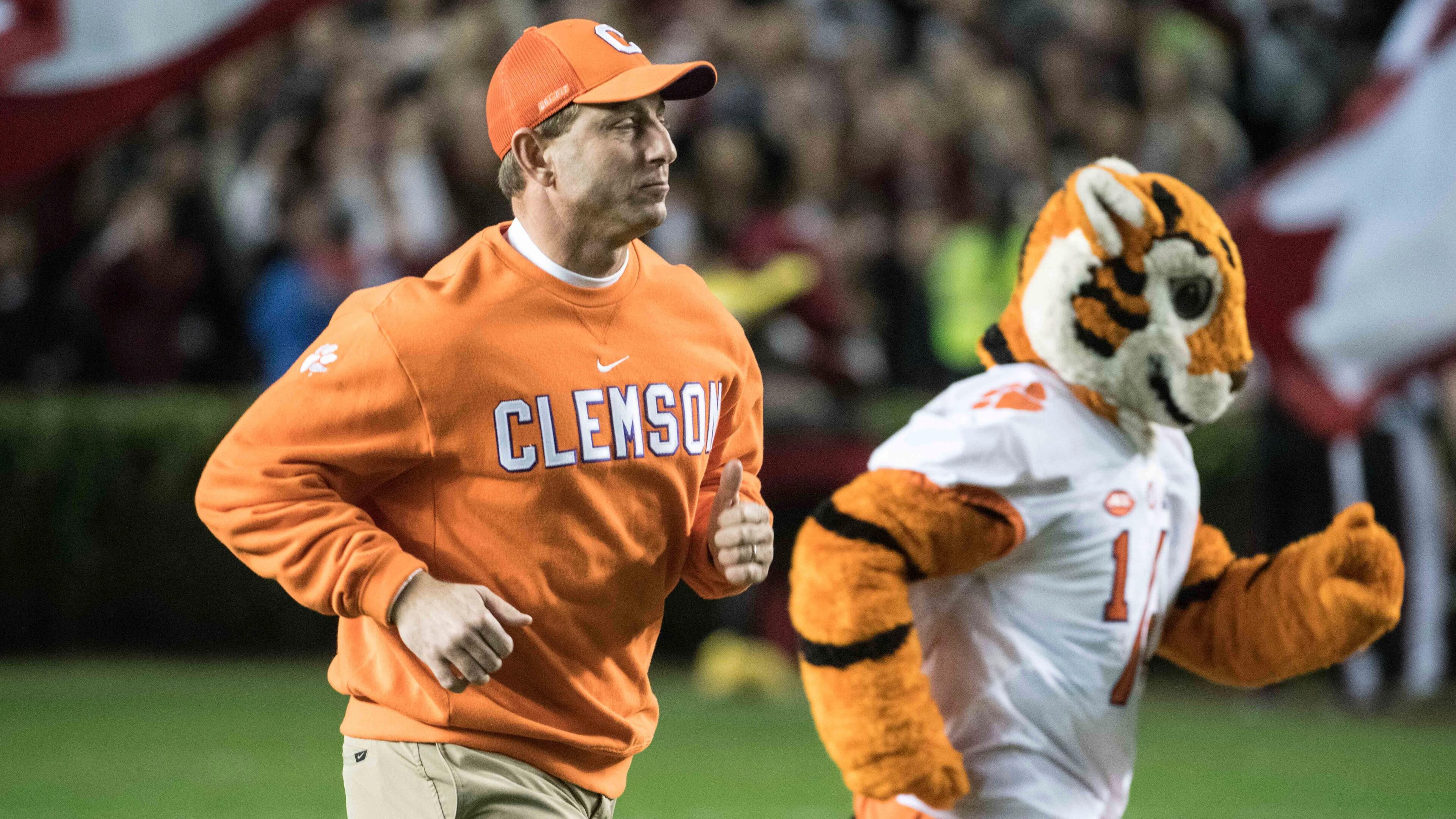 Clemson head coach Dabo Swinney runs onto the field with one of his friends before last week's victory over rival South Carolina. (AP Photo/Sean Rayford)